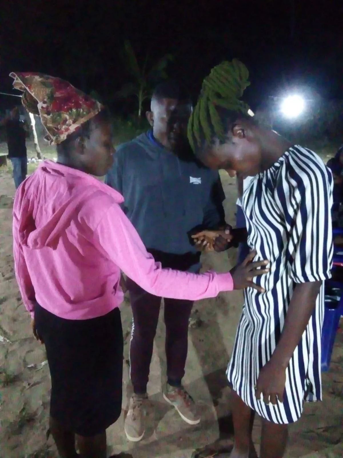 A team member praying with two young women at the night outreach