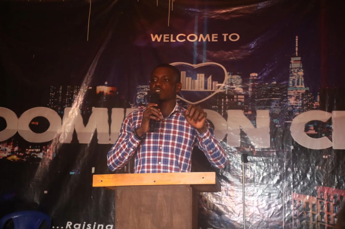 A preacher at the lectern in front of a Welcome to Dominion City backdrop