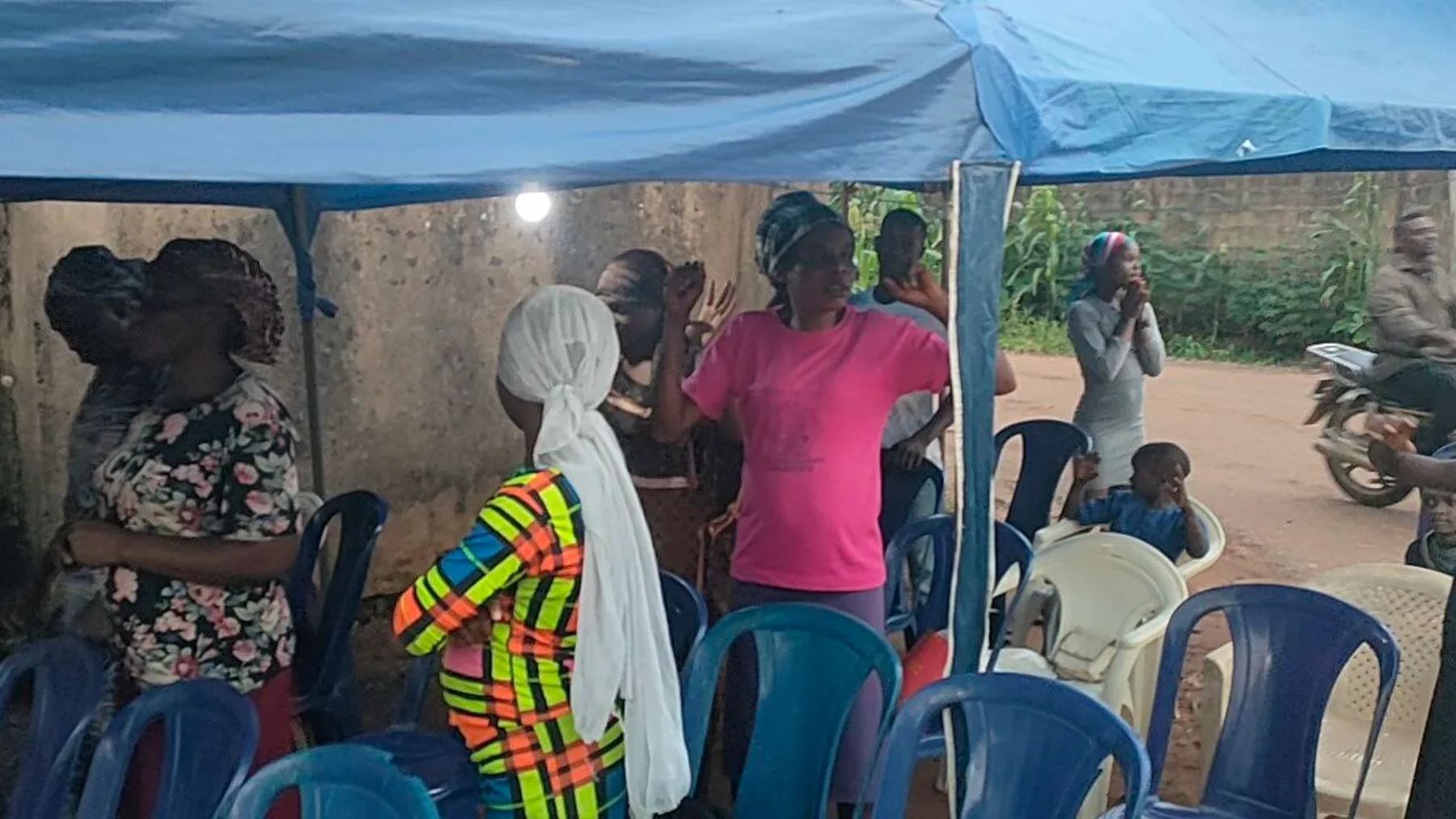 Women praying under the canopy