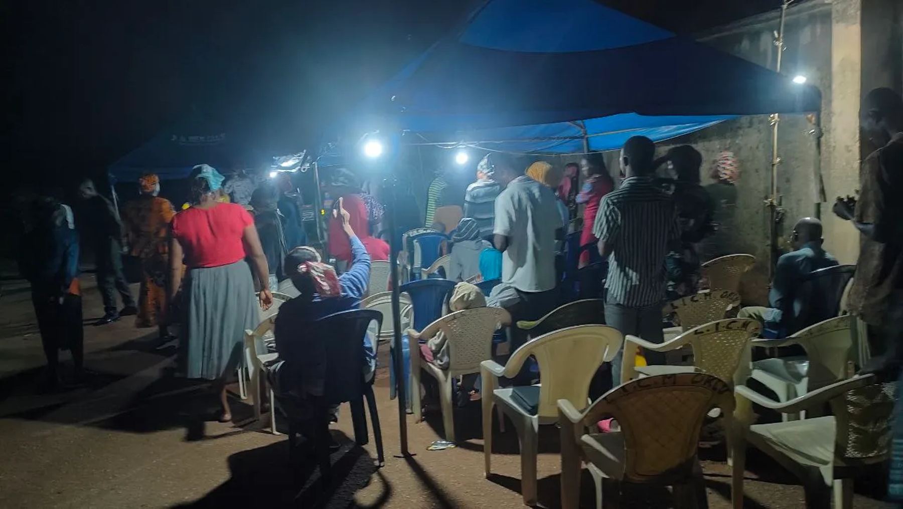 People gathered under lit canopies at night