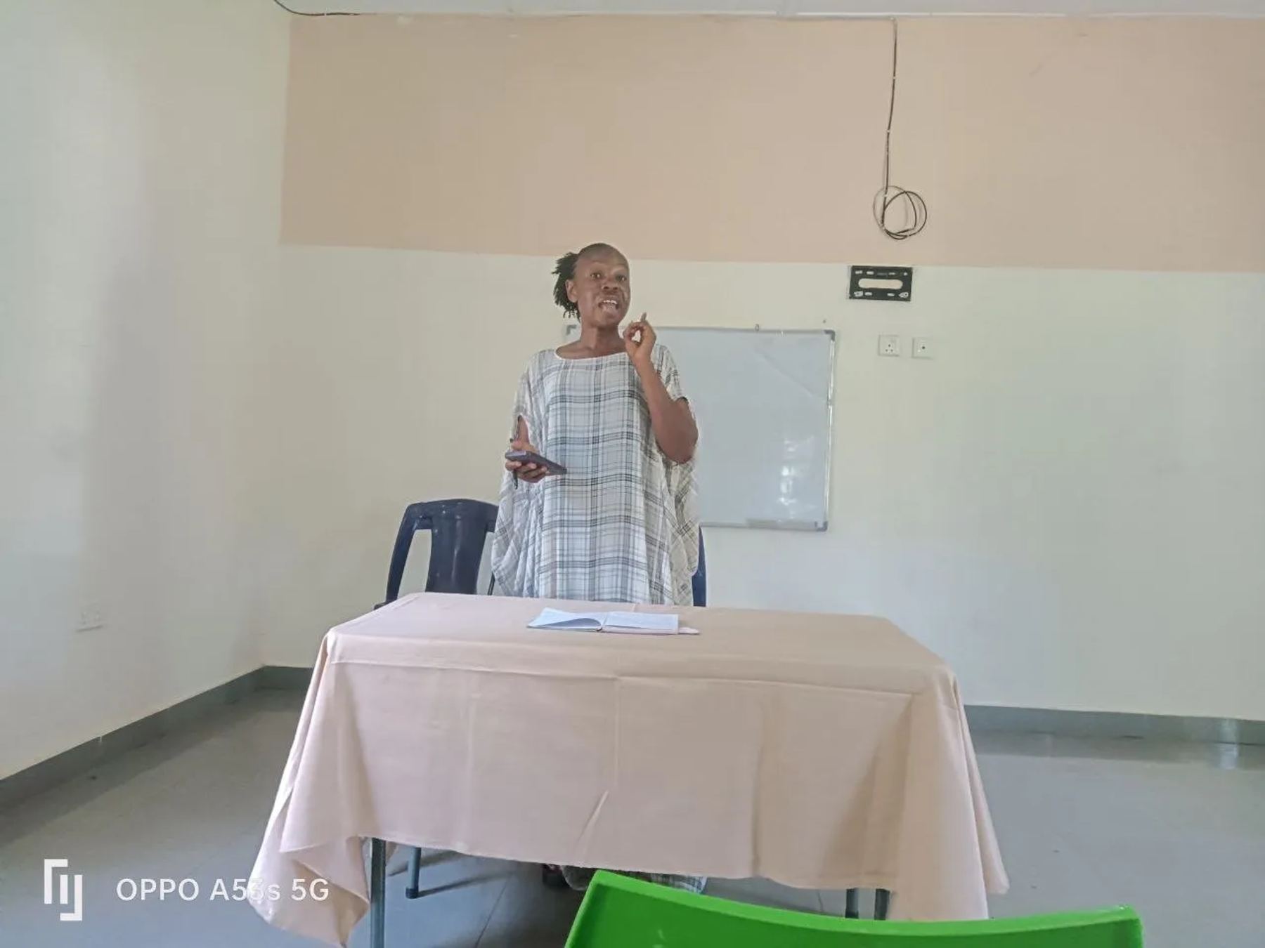 A speaker teaching from behind a table at the front of the hall