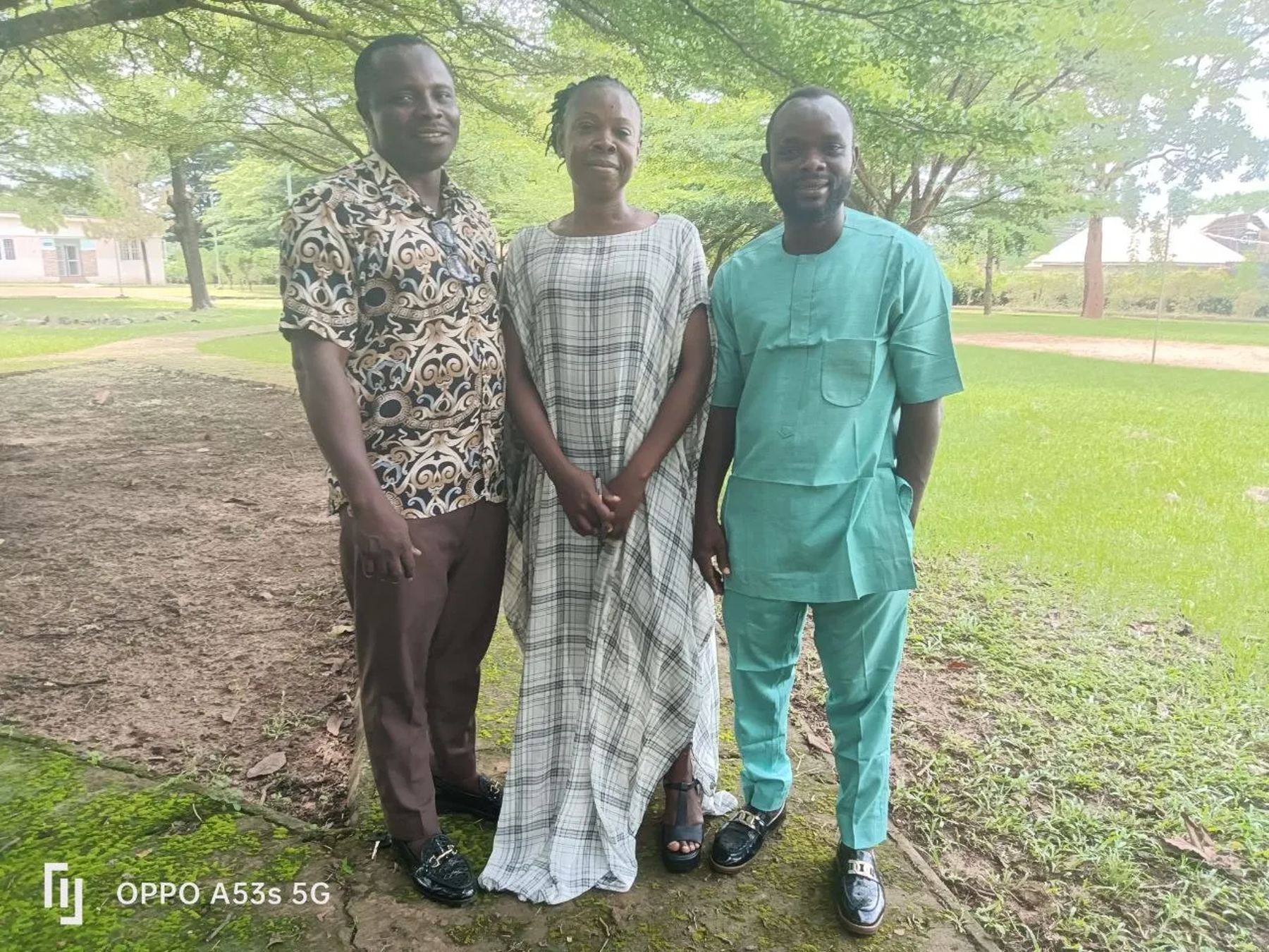 Three members of the team standing together on the grass outside