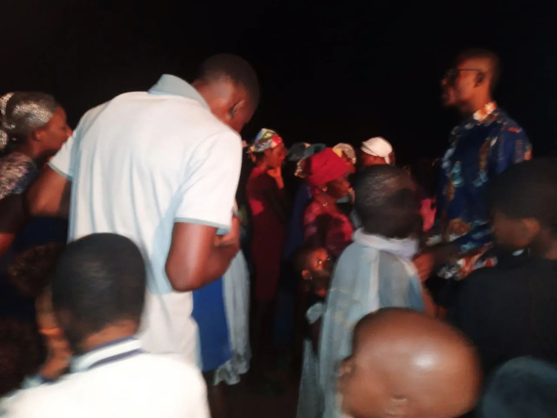 Team members praying with people at night