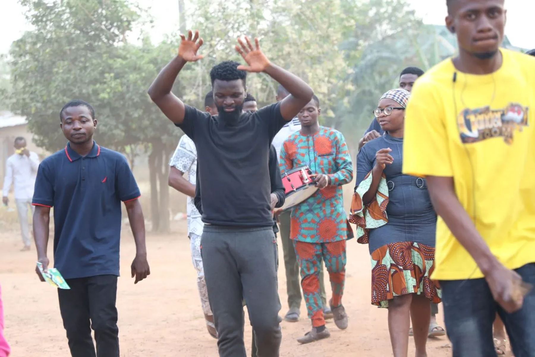 The team walking through the town, one with arms raised