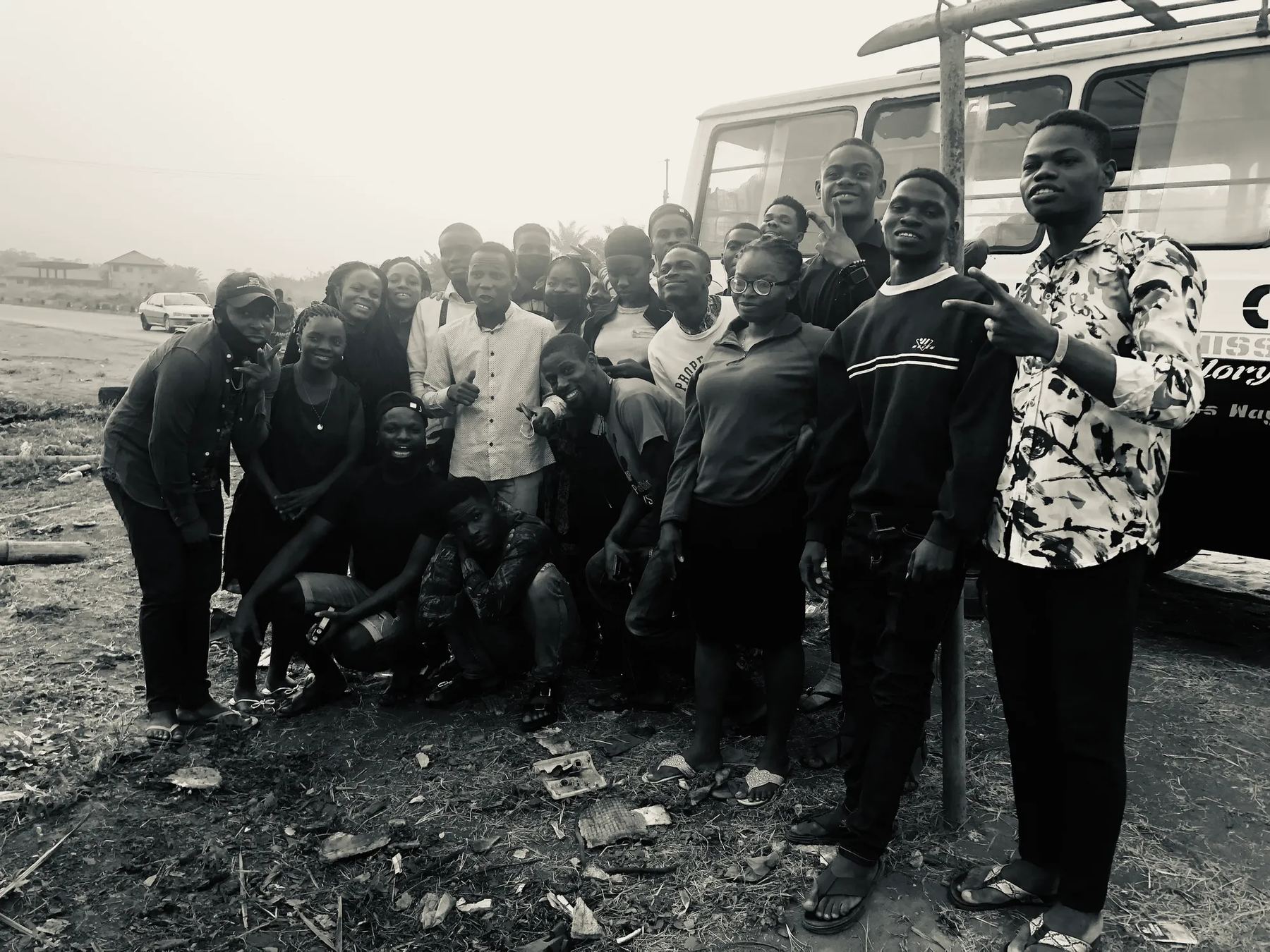 The team in a black-and-white group photo beside a bus