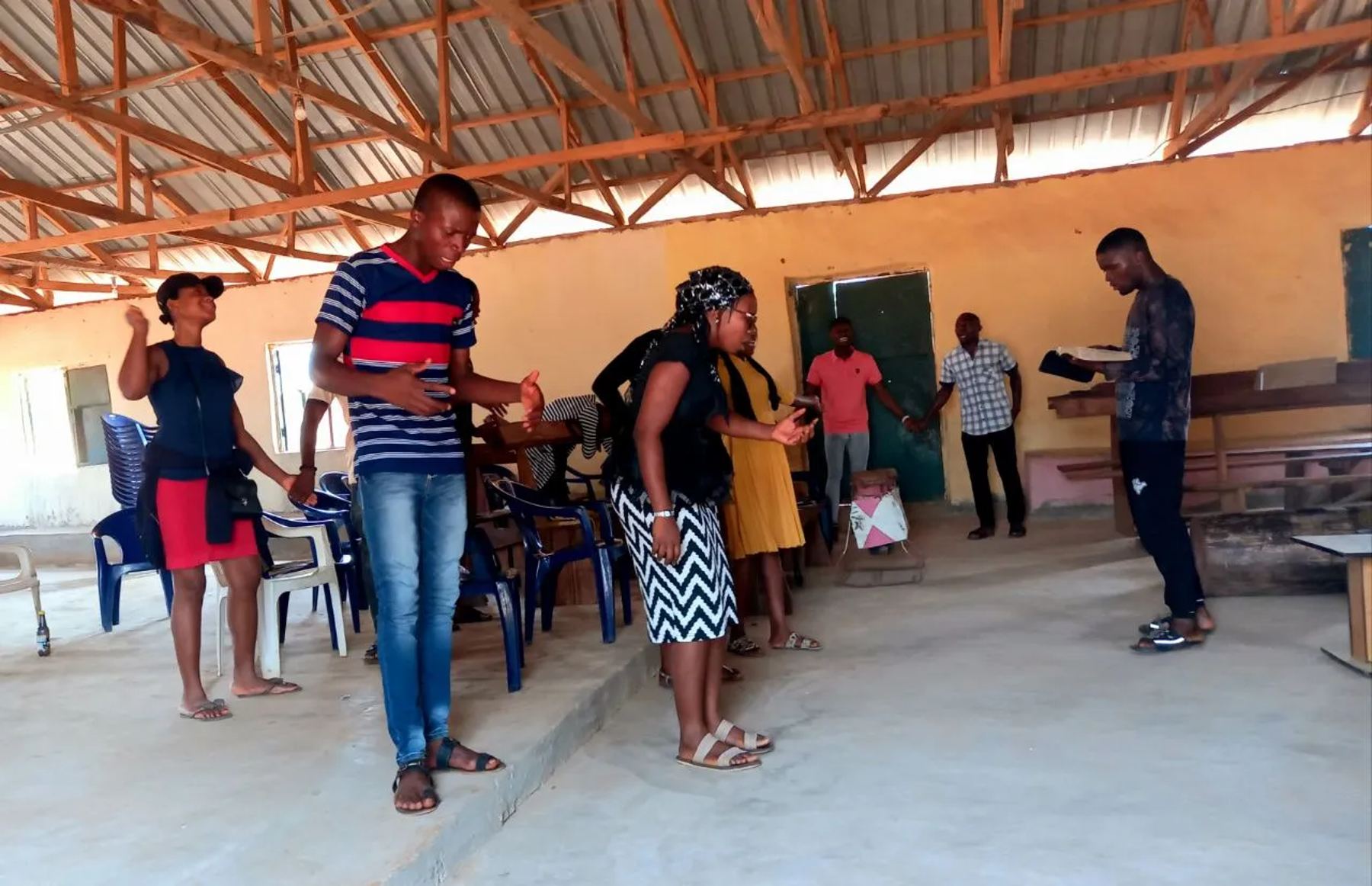 Team members praying inside an open-sided hall