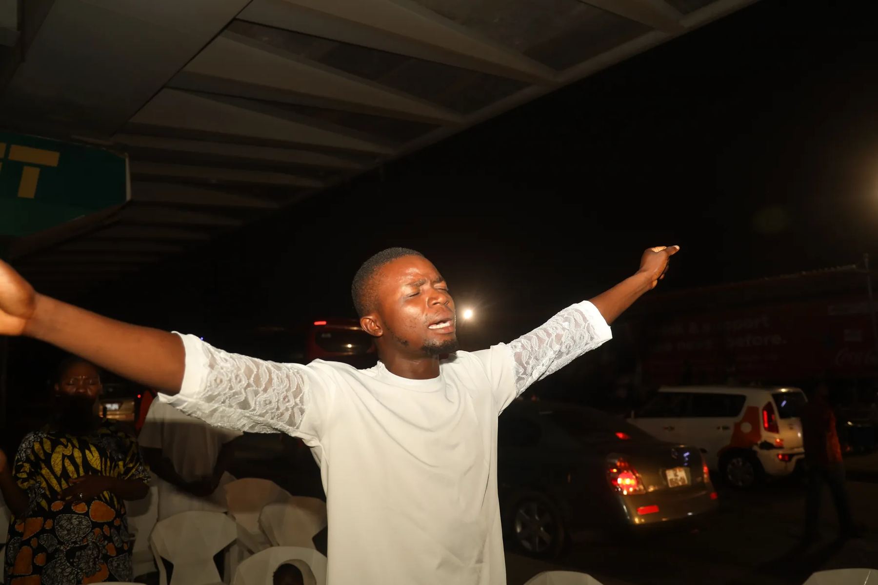 A young man with arms outstretched in worship