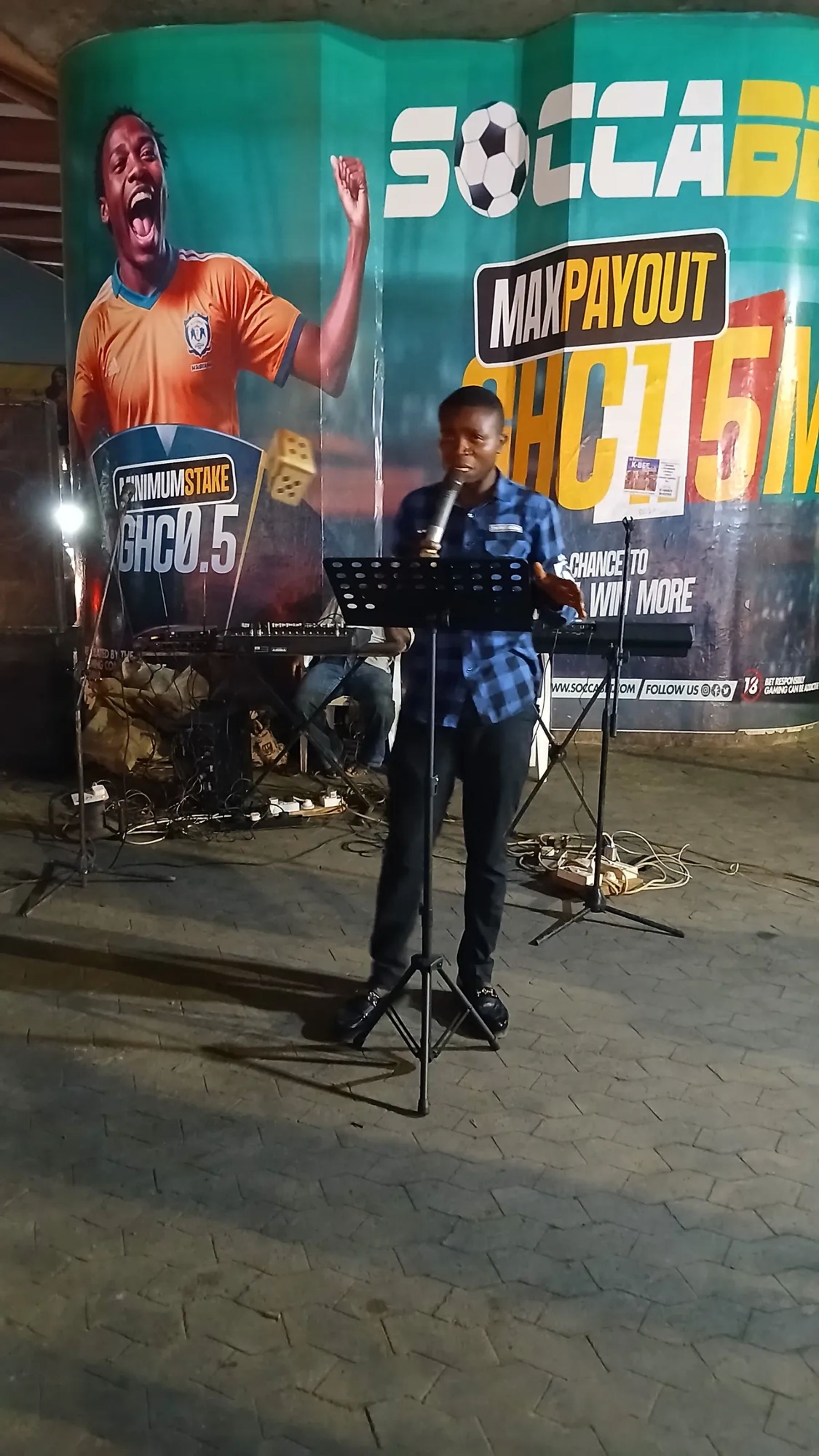 A speaker with a microphone and music stand on the street-side platform at night