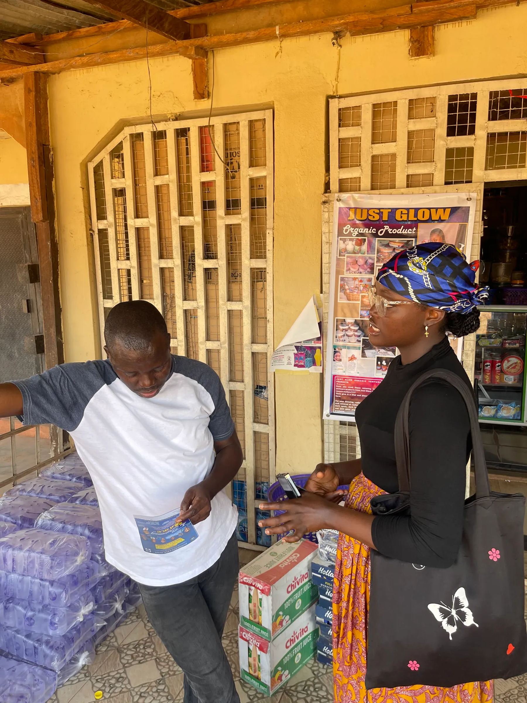 A team member sharing a tract with a woman at a shop front