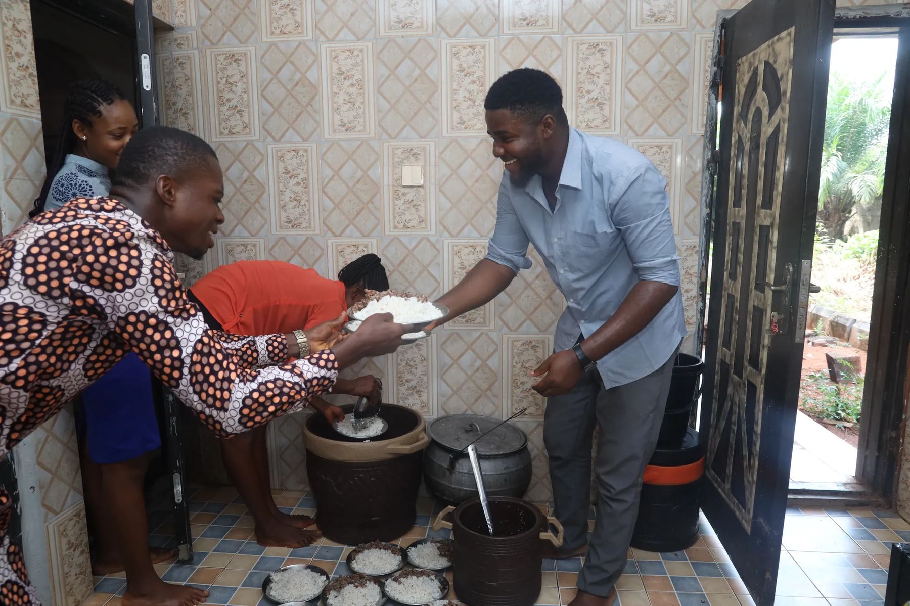 Team members serving food from pots