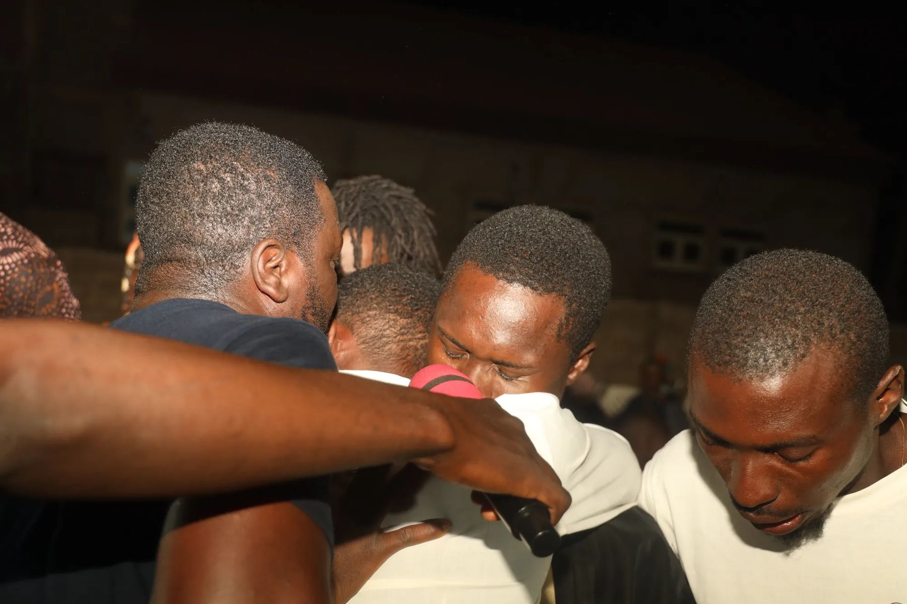 Team members praying closely together at night