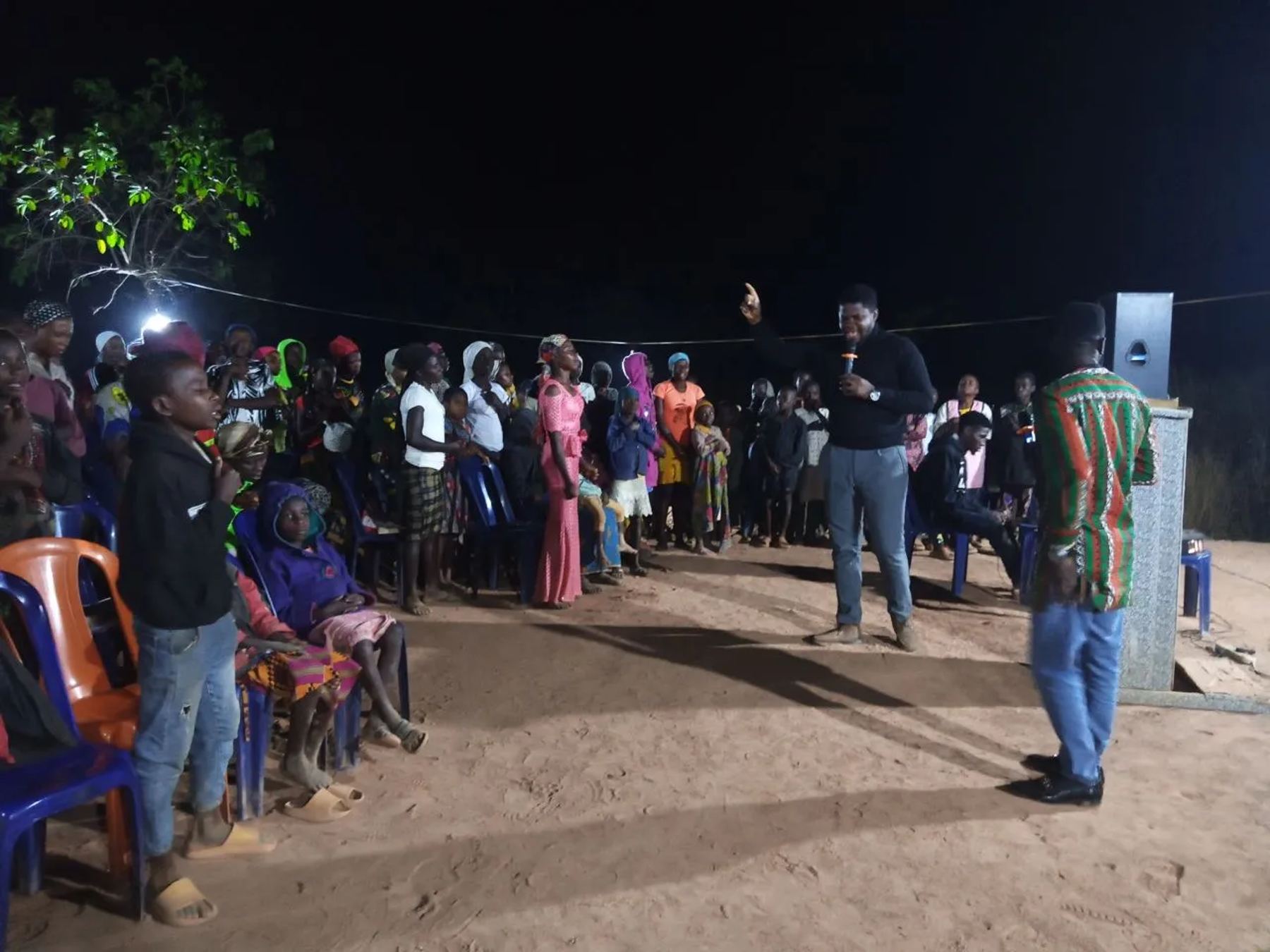 A preacher speaking to a crowd gathered at night
