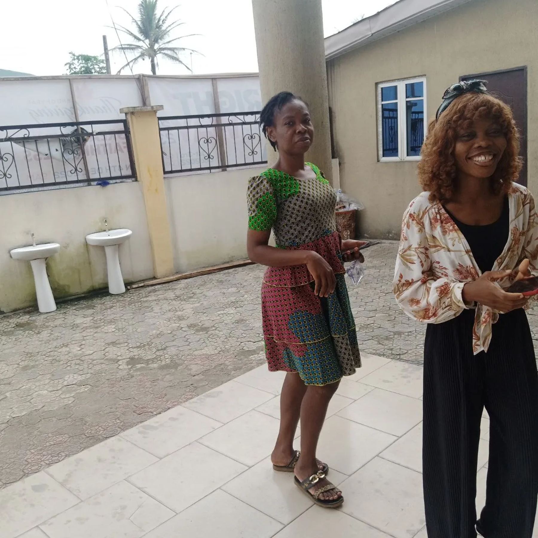 Two team members smiling in a compound