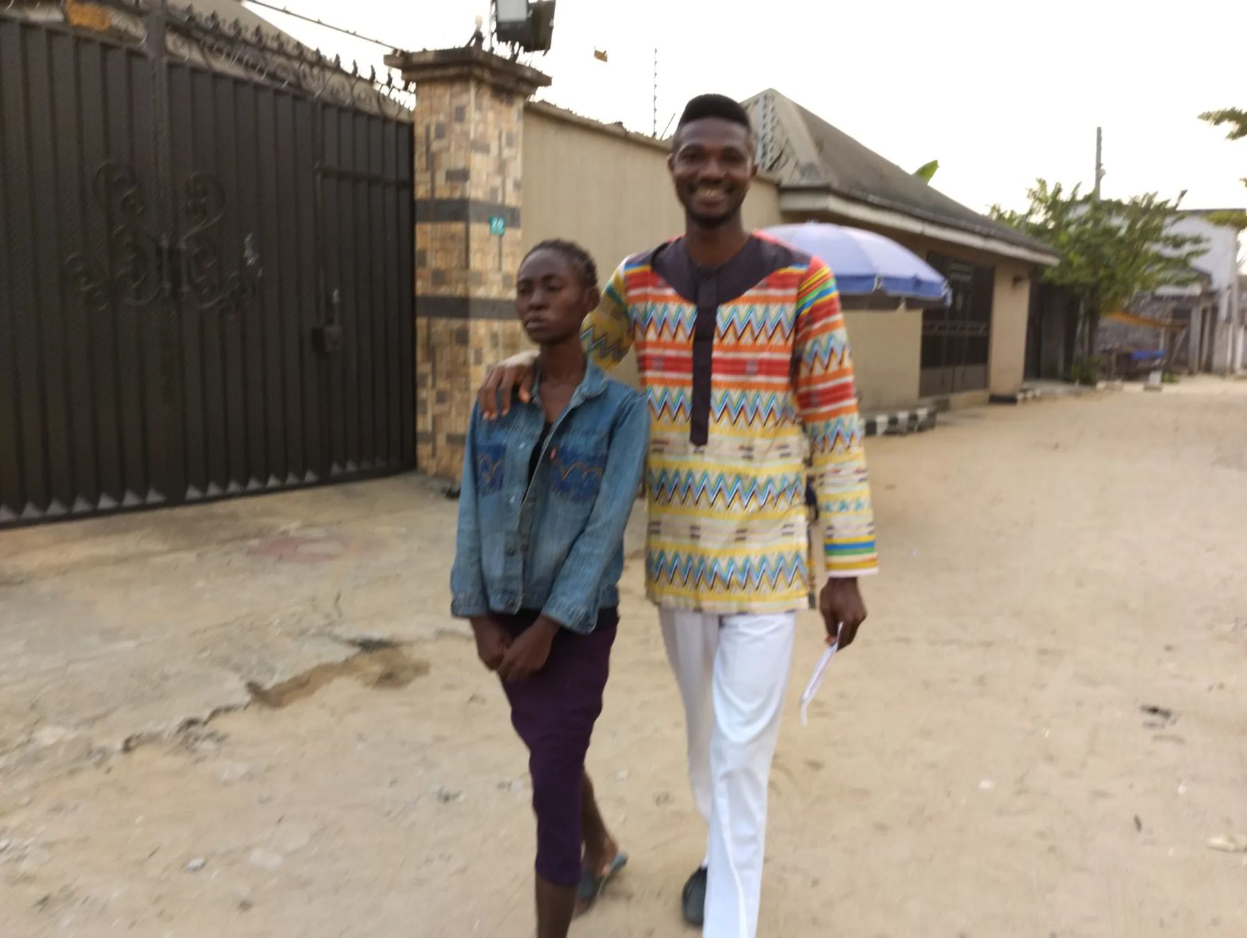 A team member walking with a young woman along the street