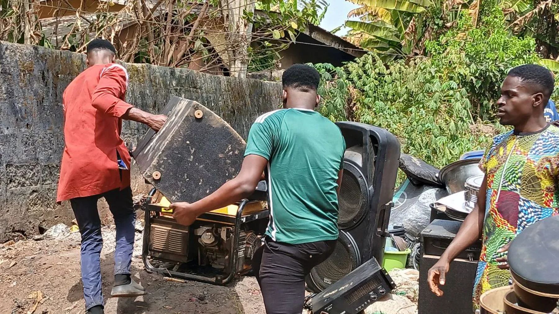 Team members carrying speakers and a generator for the crusade