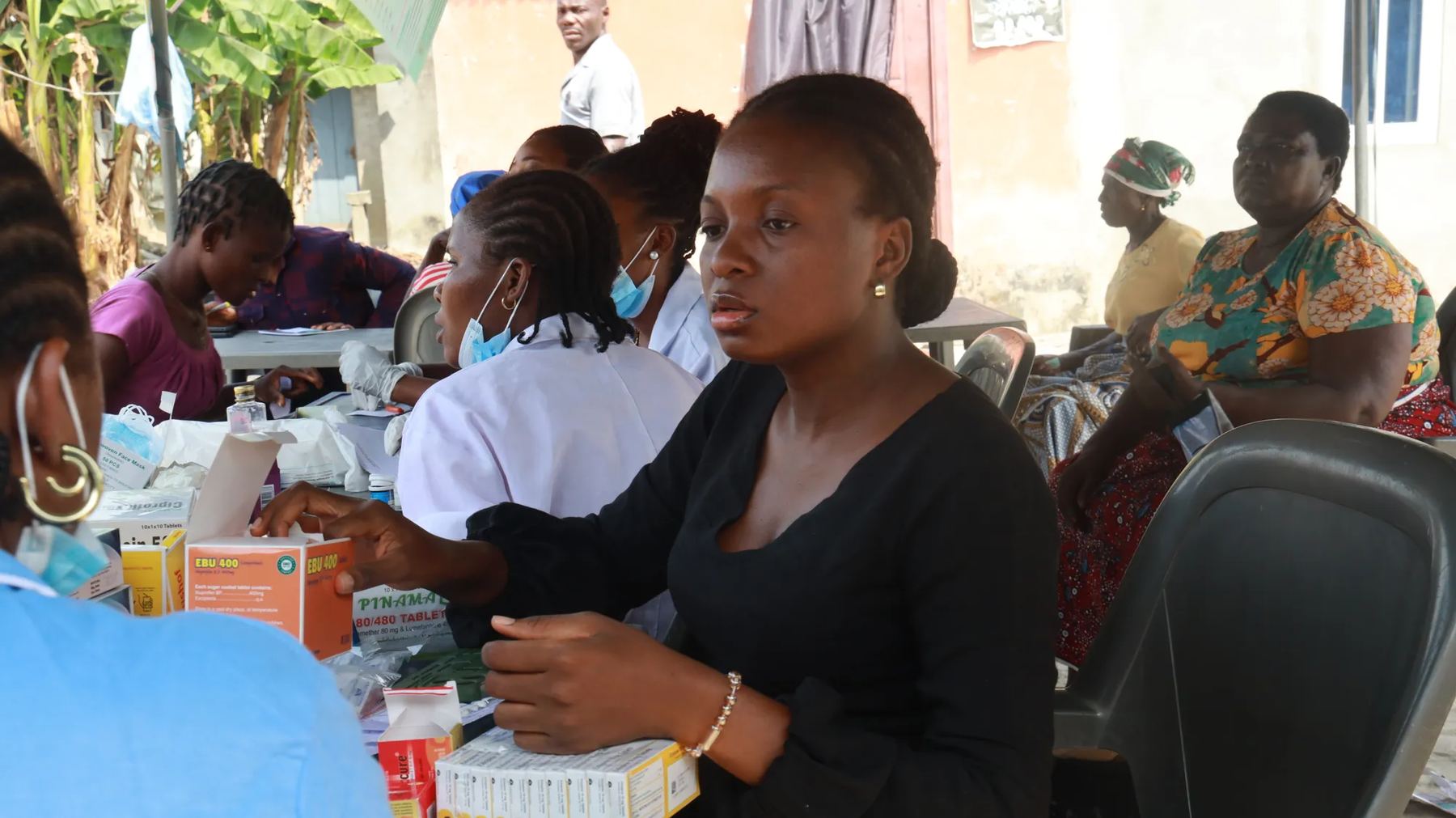 A medical outreach, with nurses and medicines at a table
