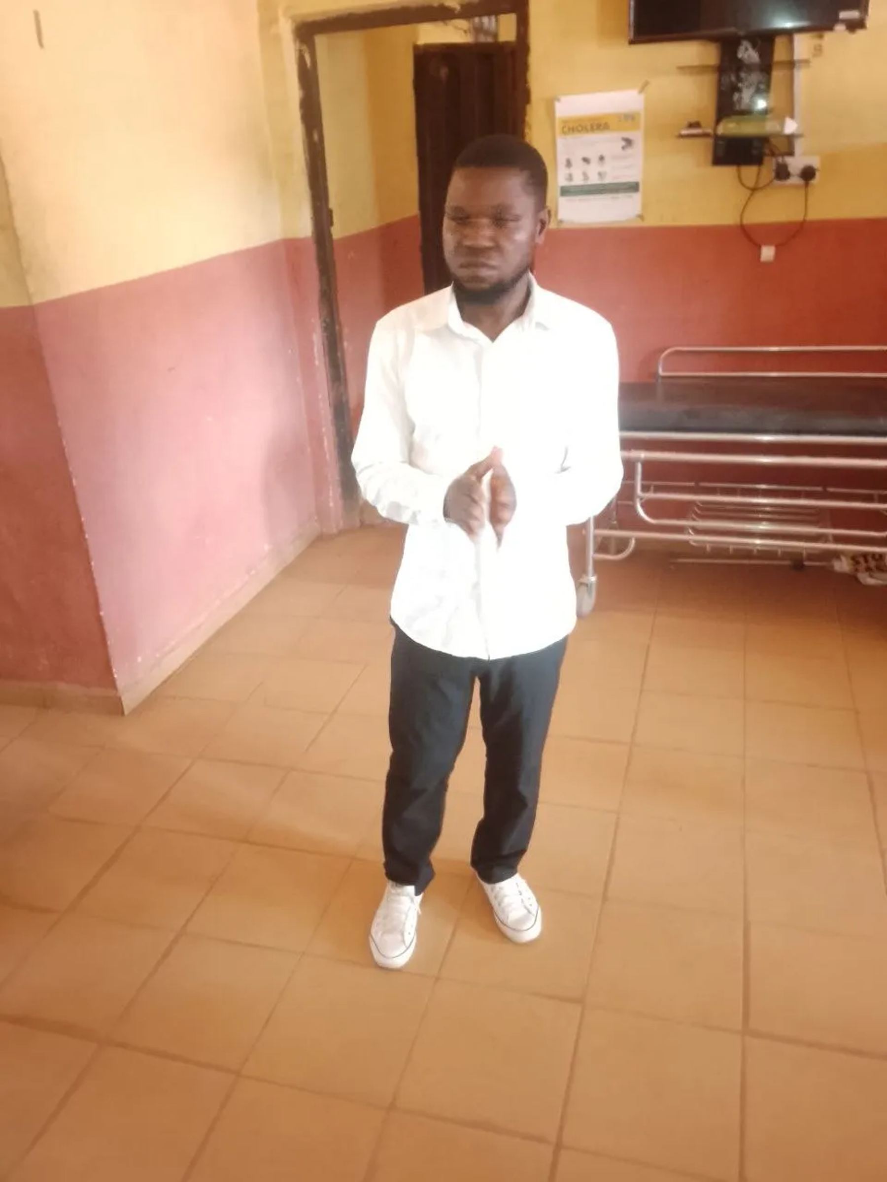 A team member standing with hands together in a hospital ward