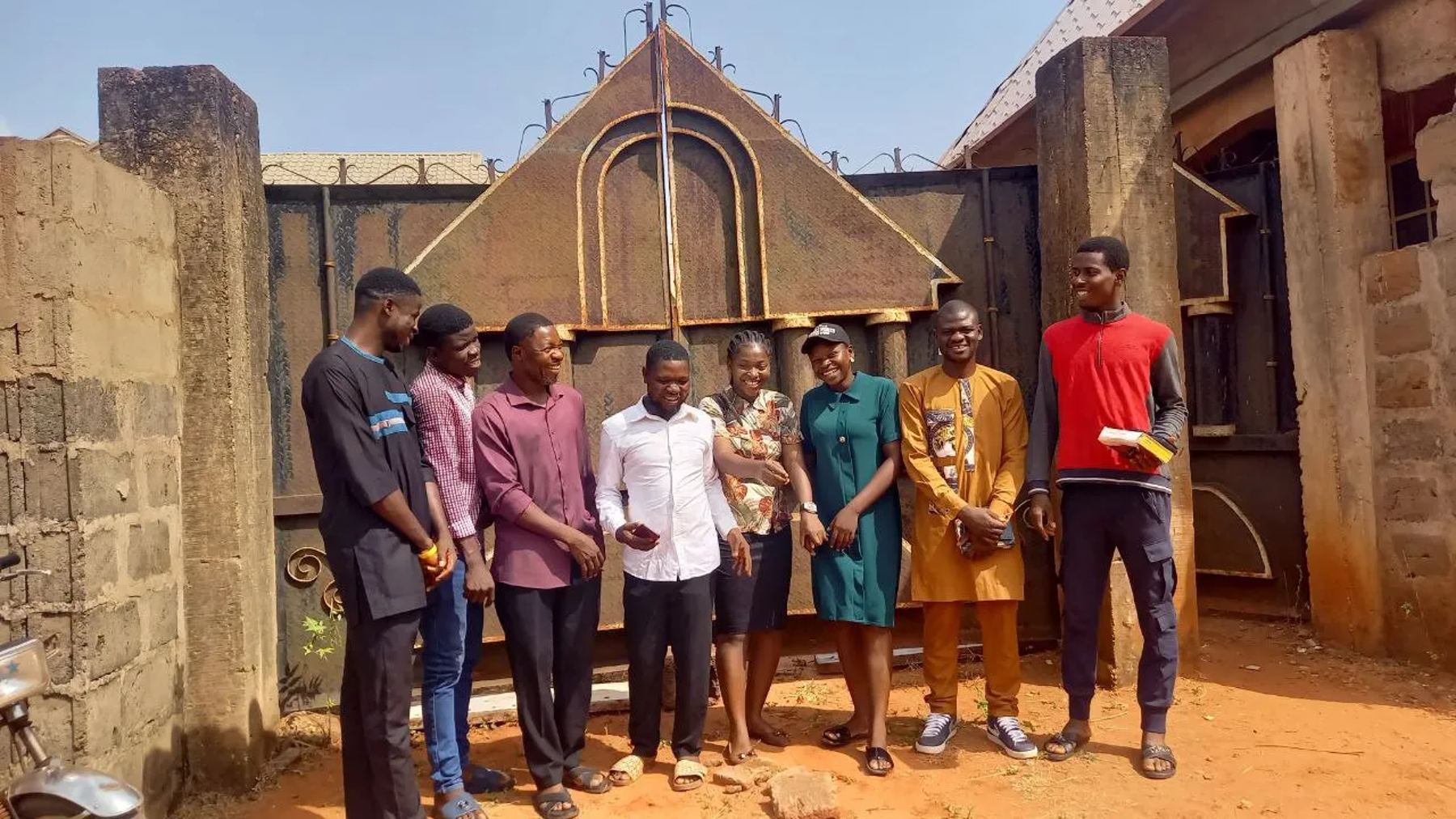 The mission team standing together in front of a gate
