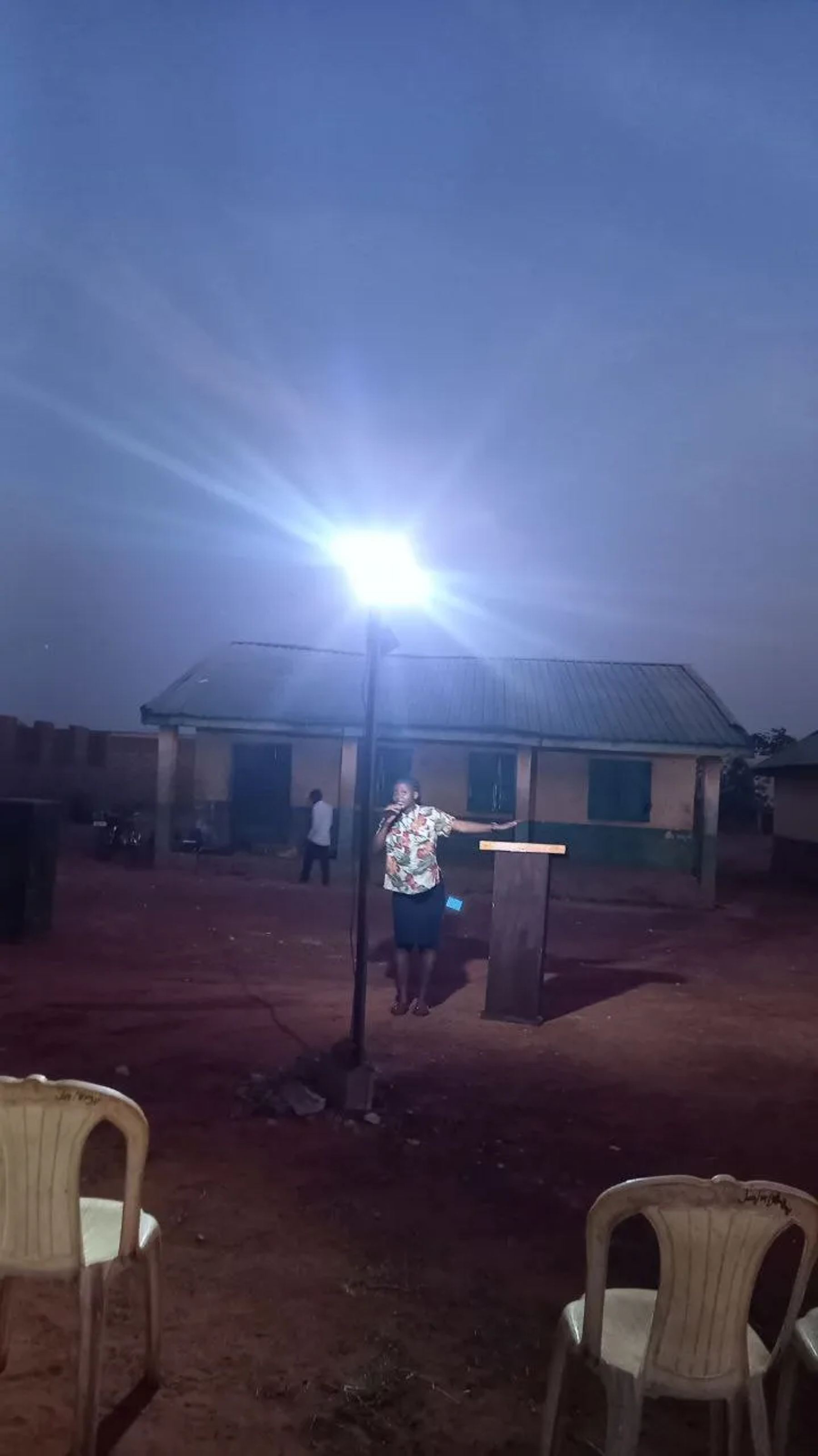A floodlight over the open-air meeting ground at dusk