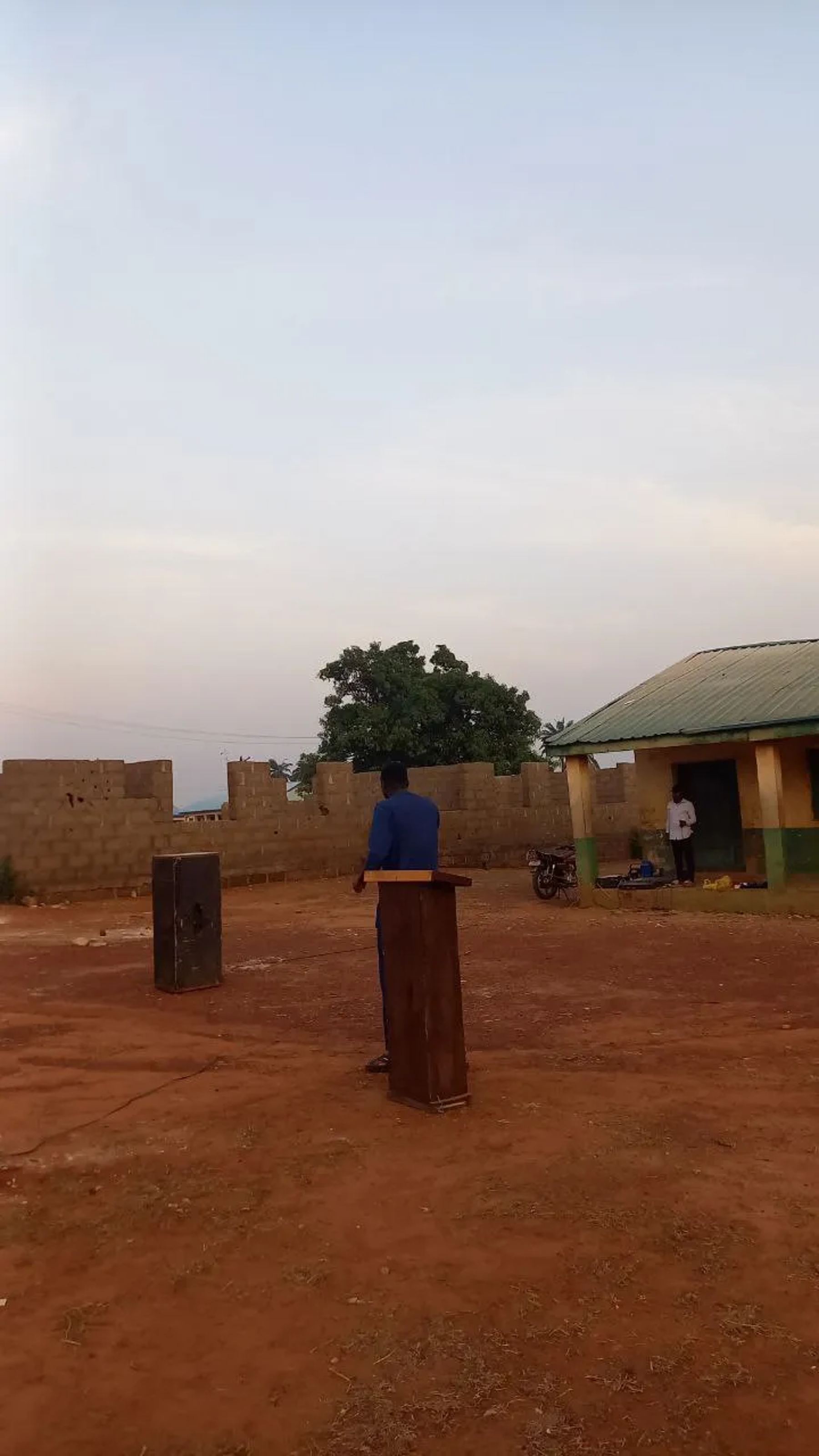 The open-air meeting ground with a lectern, set up at dusk