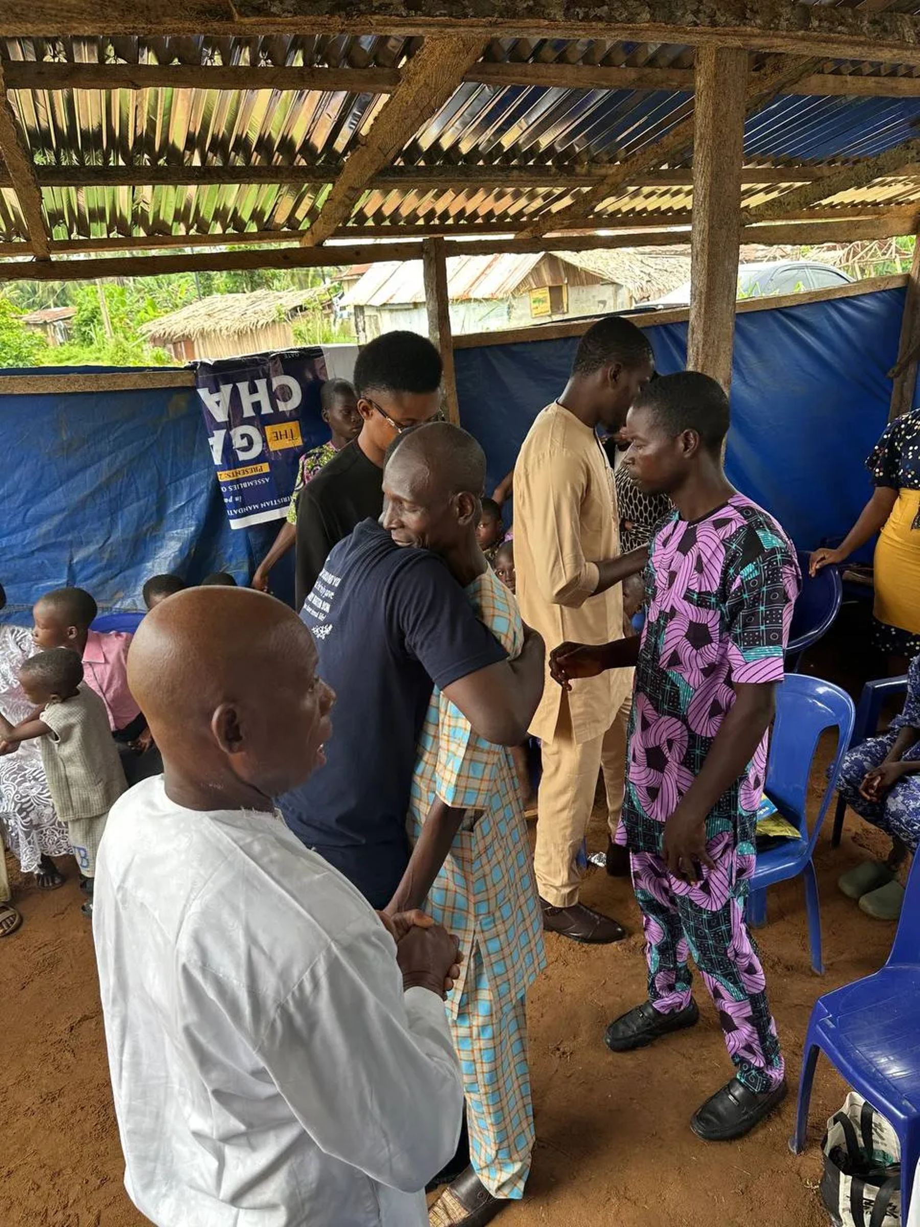 Team members and a church leader praying with young people under the canopy