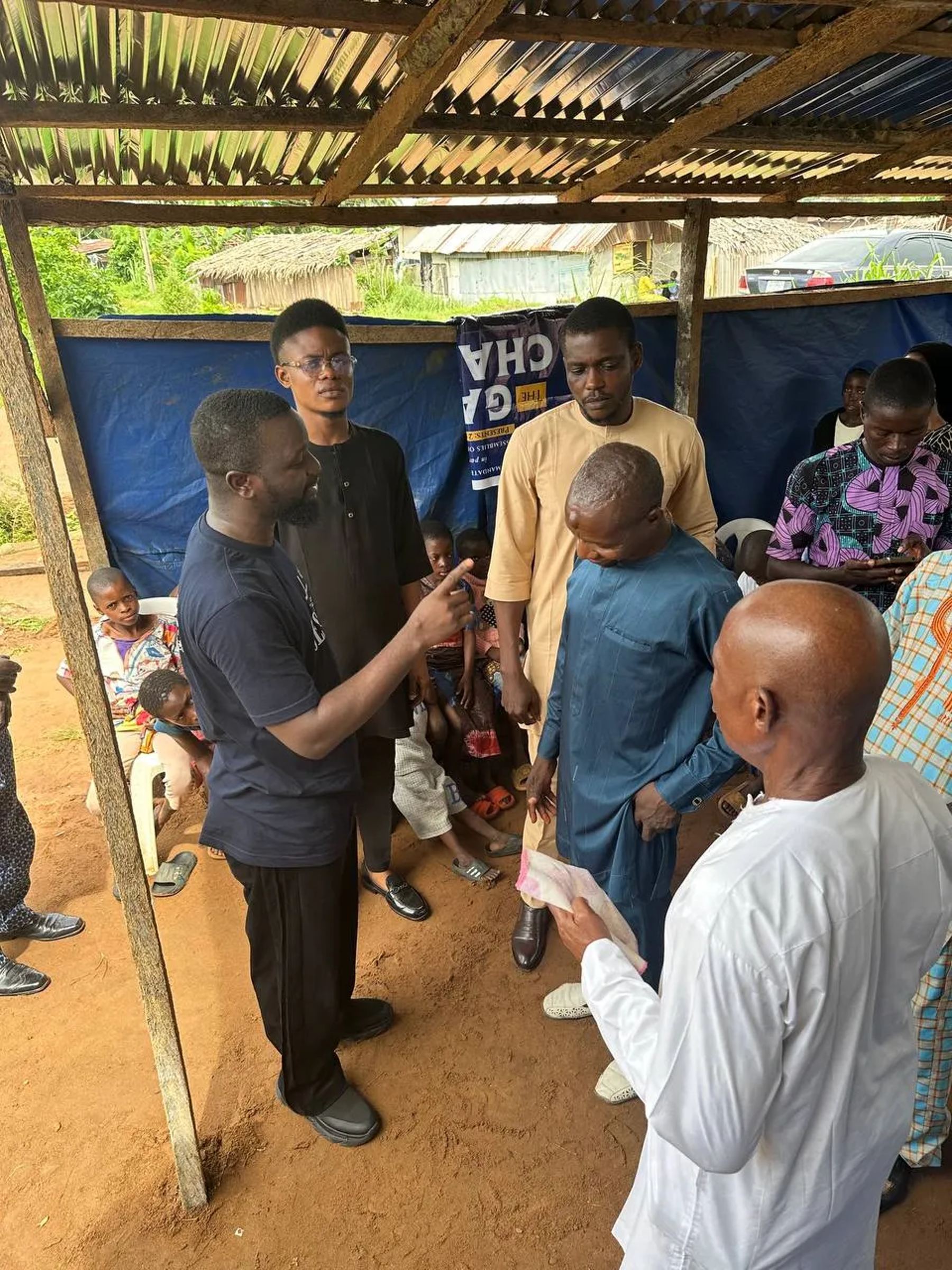 Team members and a church leader speaking with a boy under the canopy