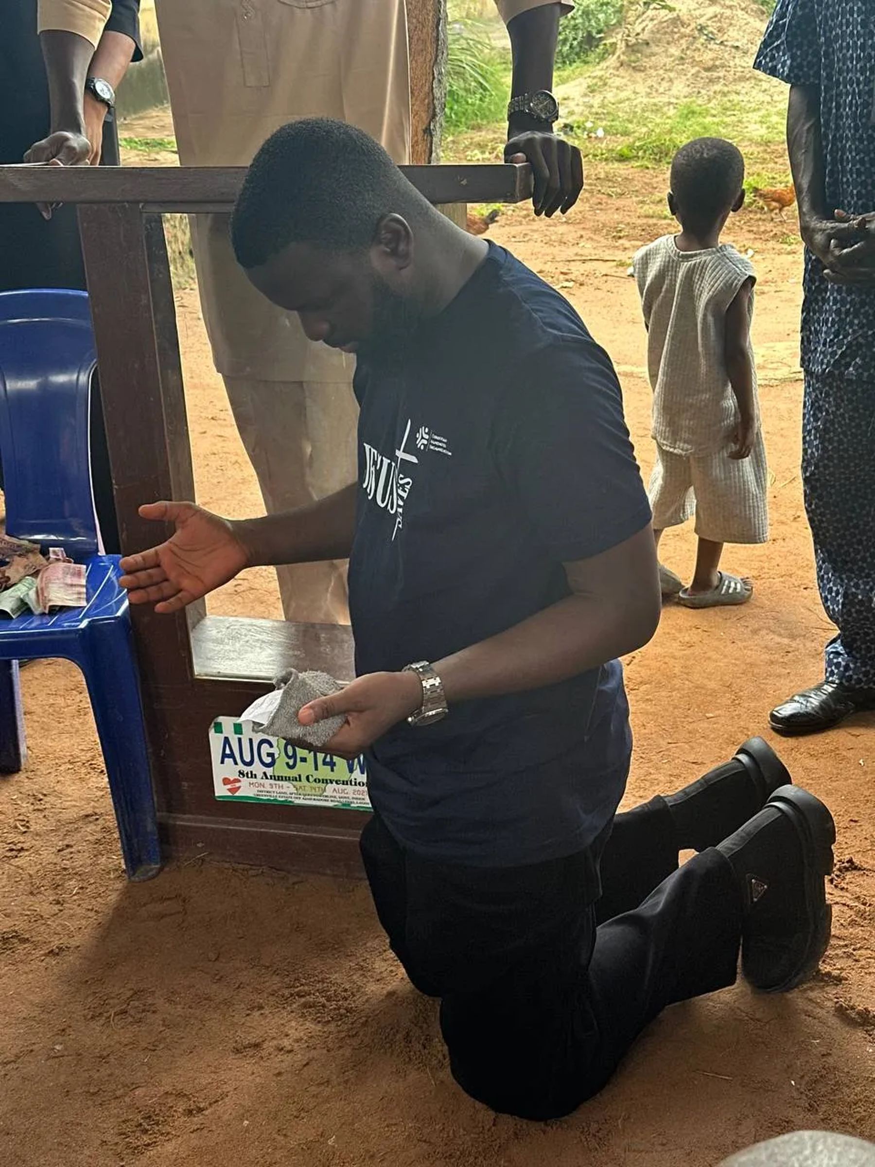A team member kneeling in prayer beside a lectern