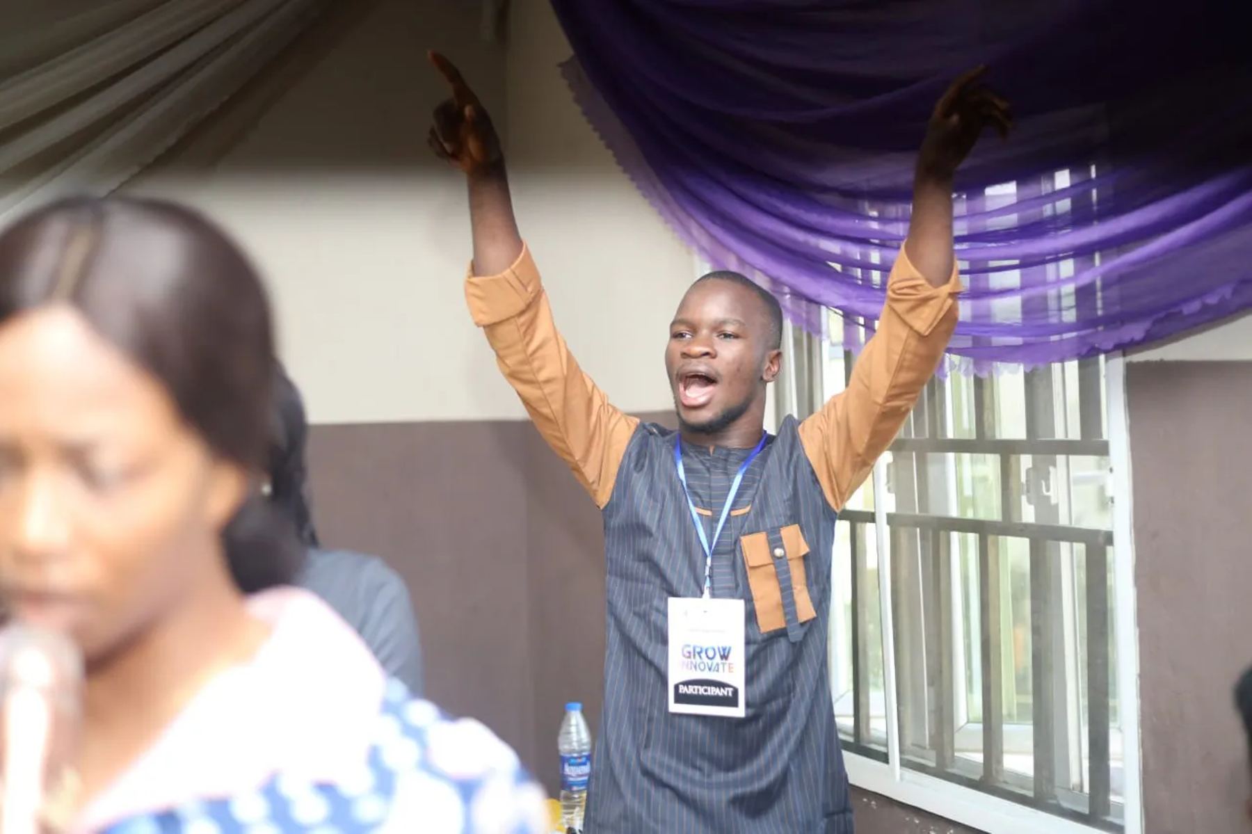 A participant with both arms raised in prayer