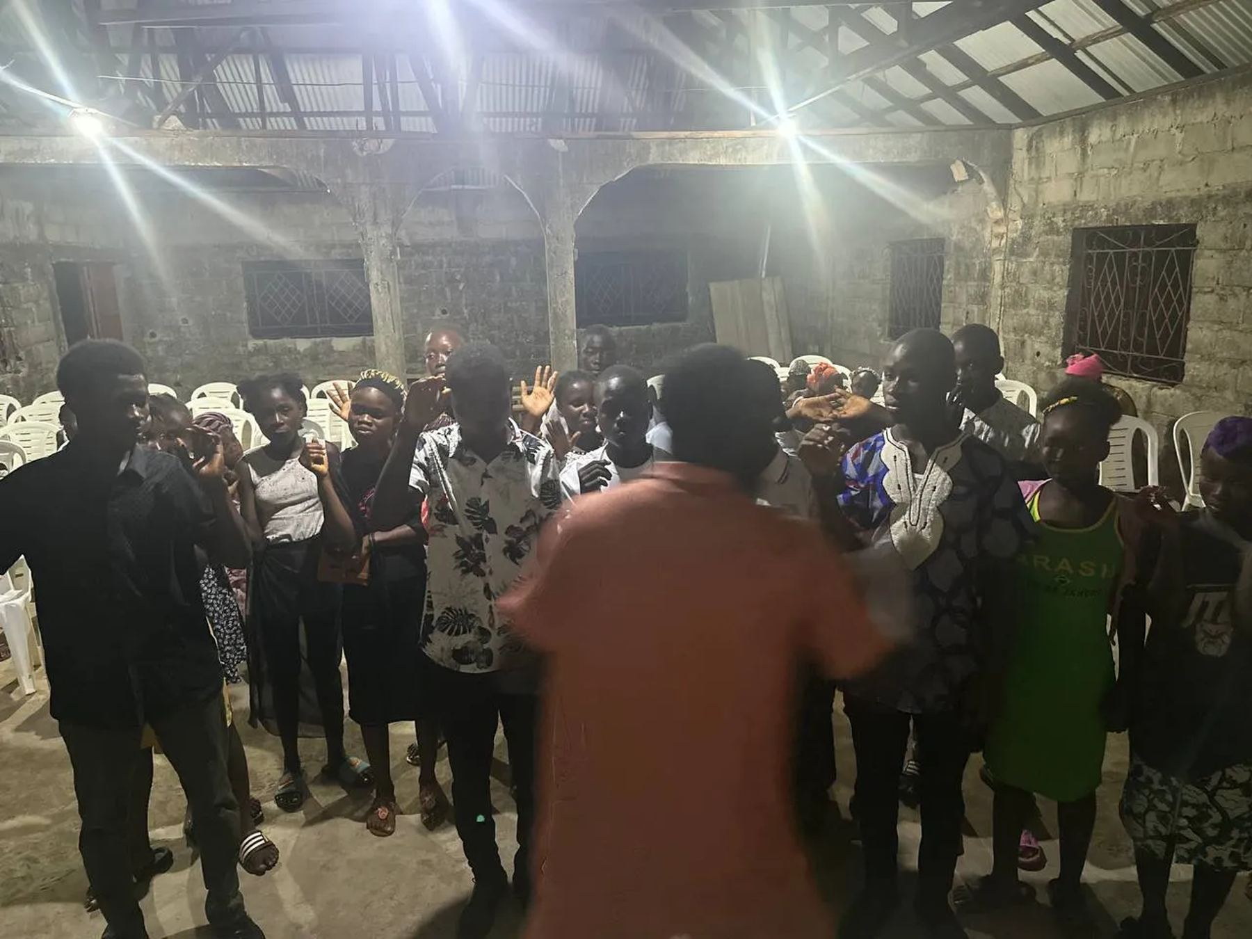Young people with raised hands at the front of the church