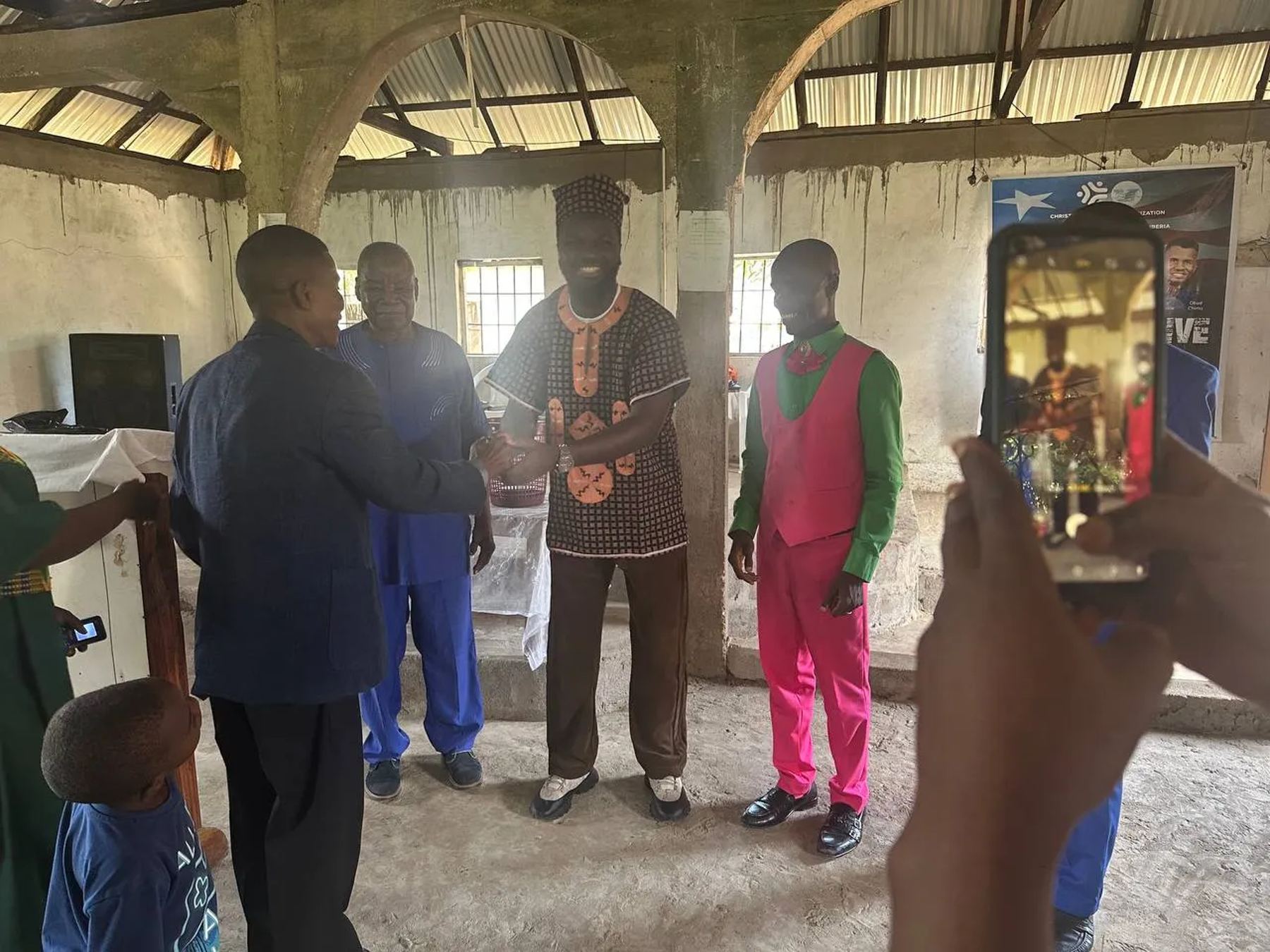 Team members greeting church leaders as someone films on a phone