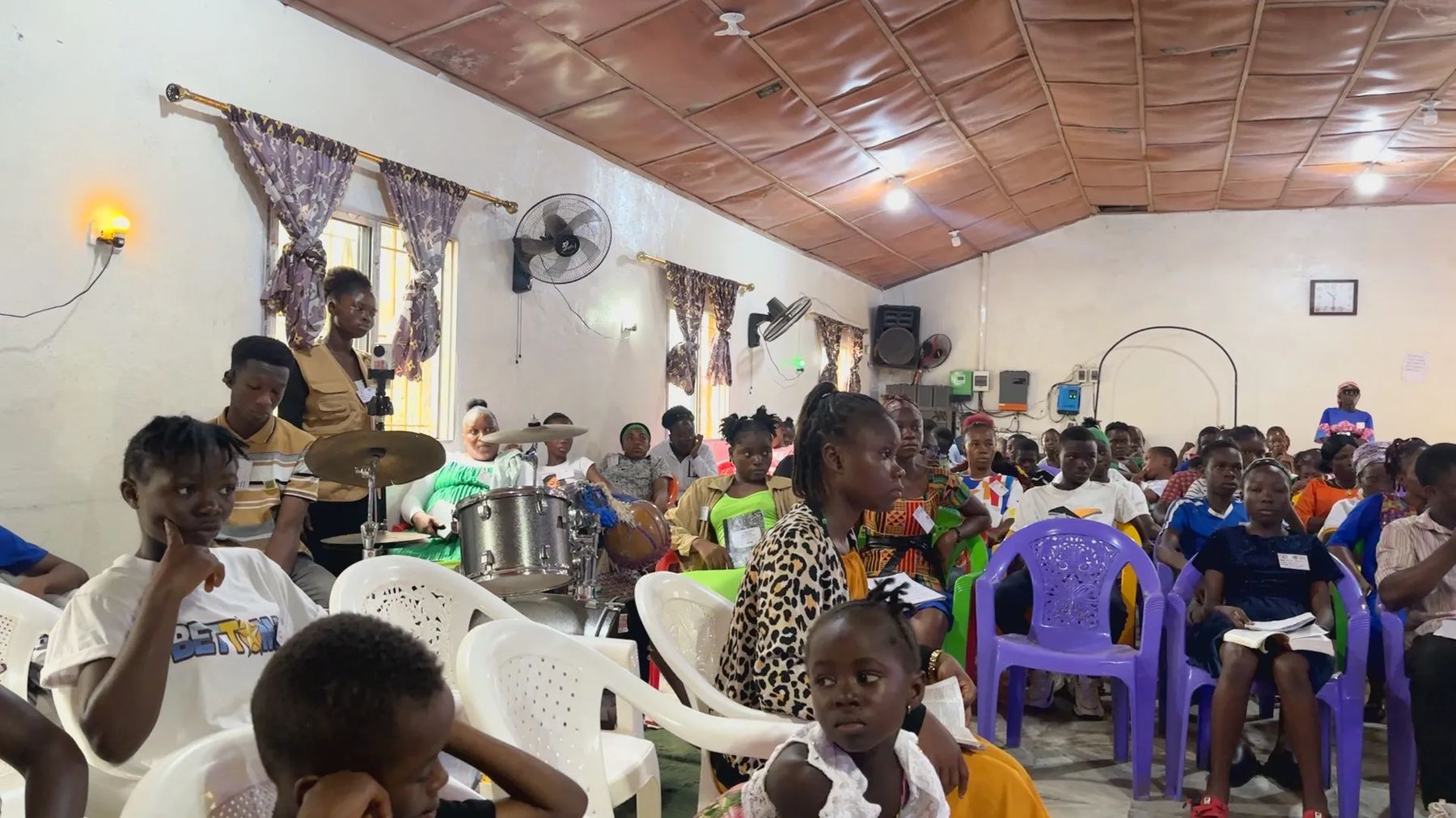 Young people and adults seated in the hall during a session