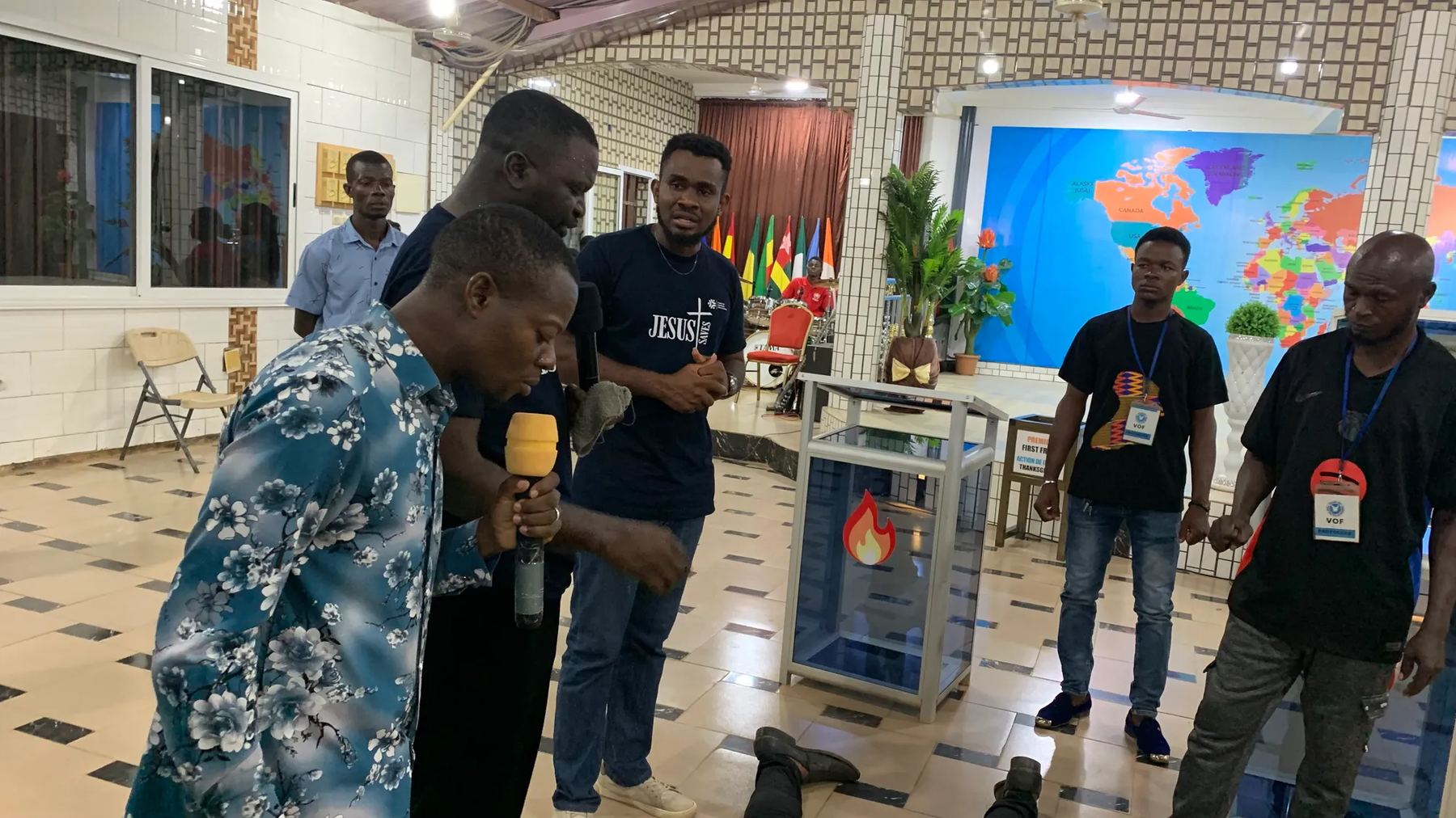 Team members praying together near the front of the hall