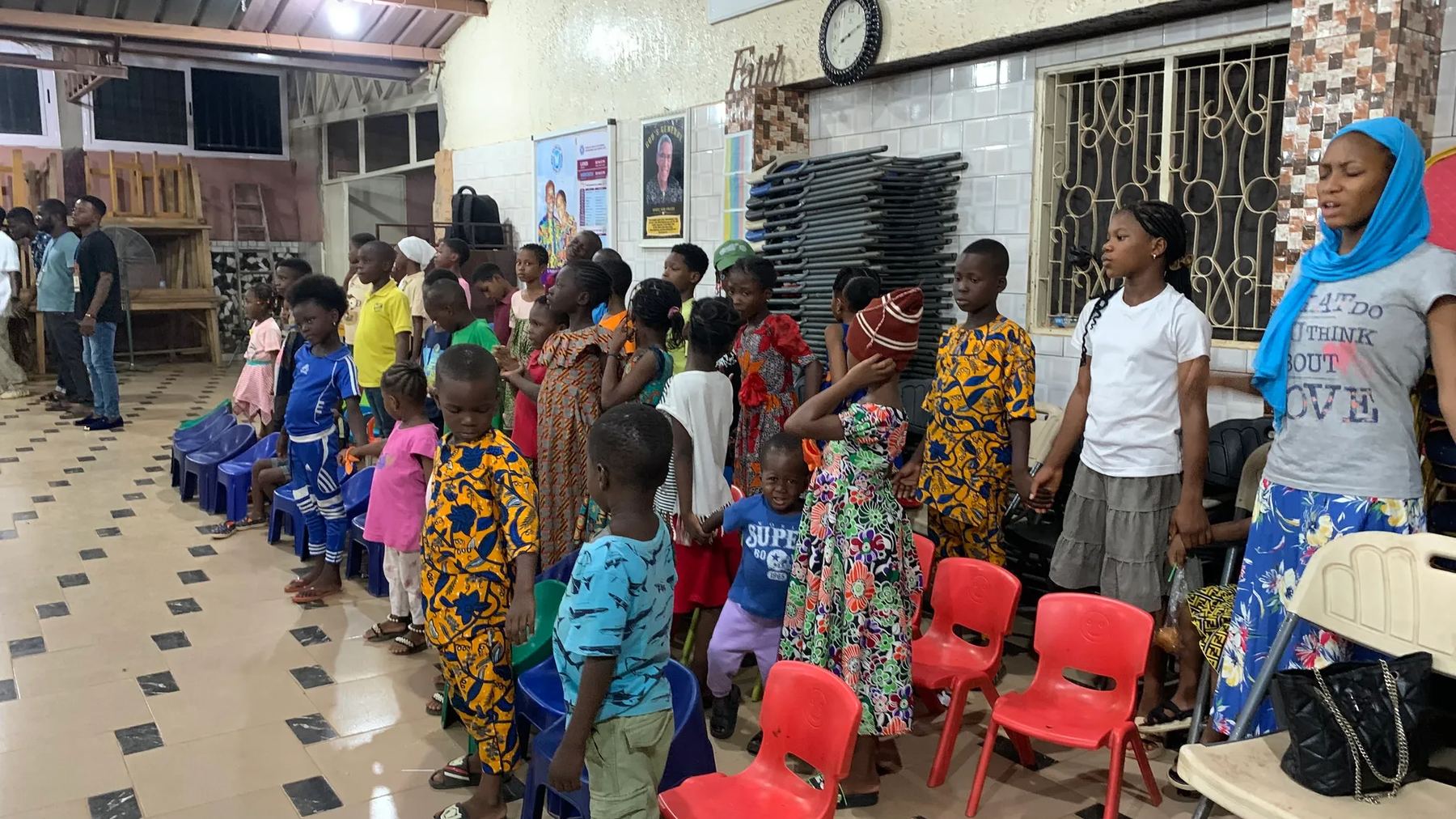Children and young people standing in rows in the hall