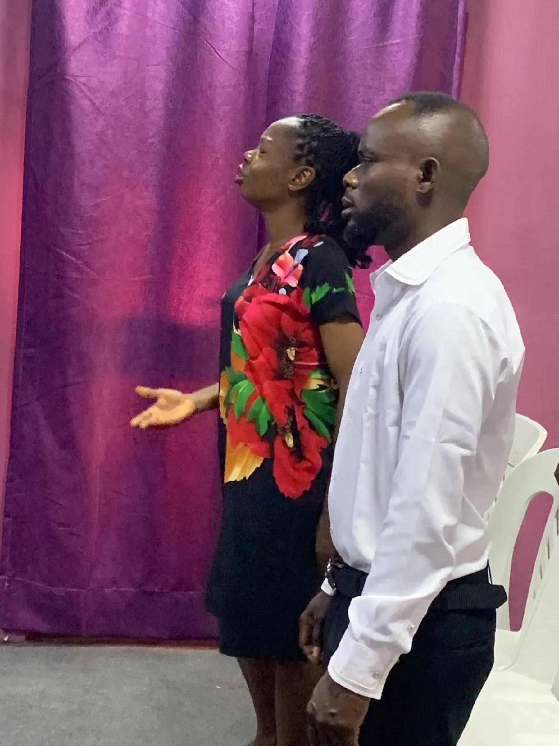 A woman and a man praying at the front of the church