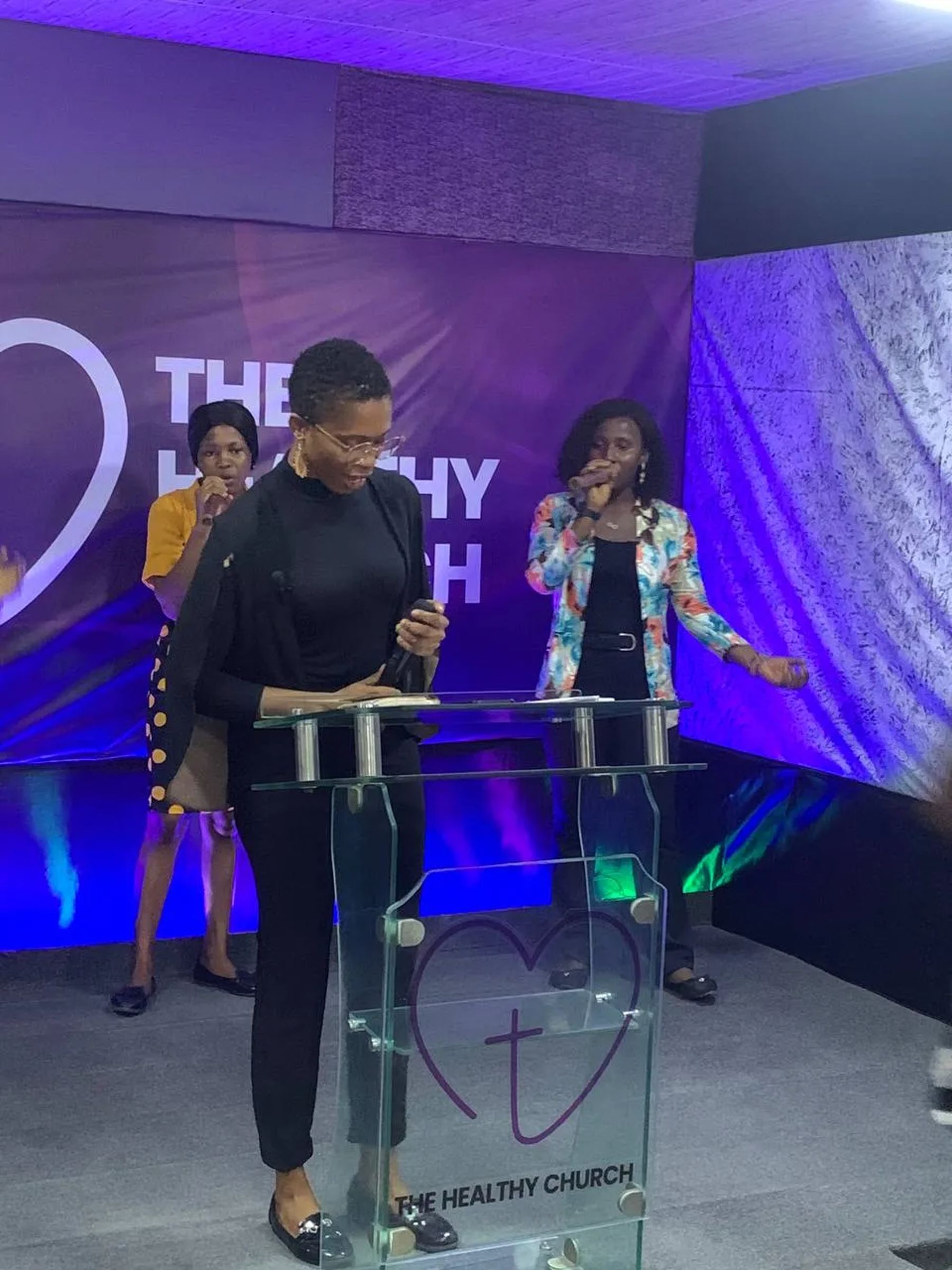 Two women at the lectern on the stage, one with a microphone