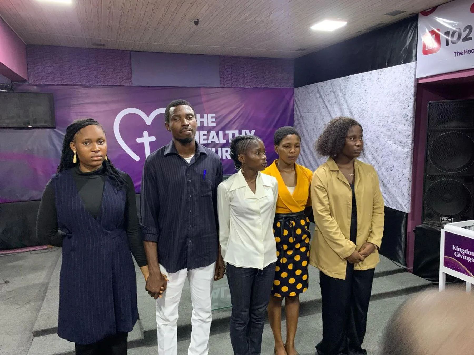 Five young people holding hands at the front of the church
