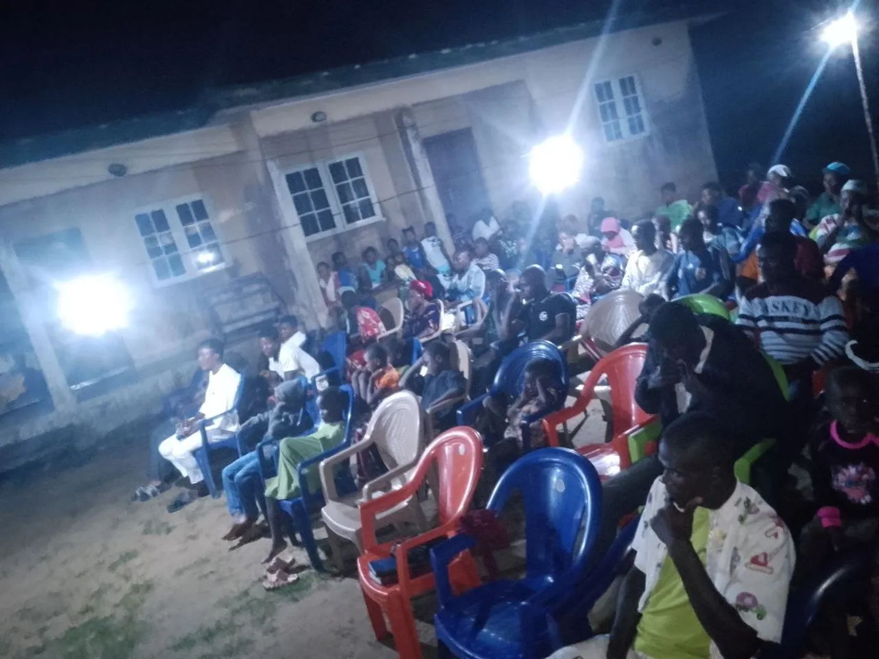 The courtyard full of people under floodlights at night