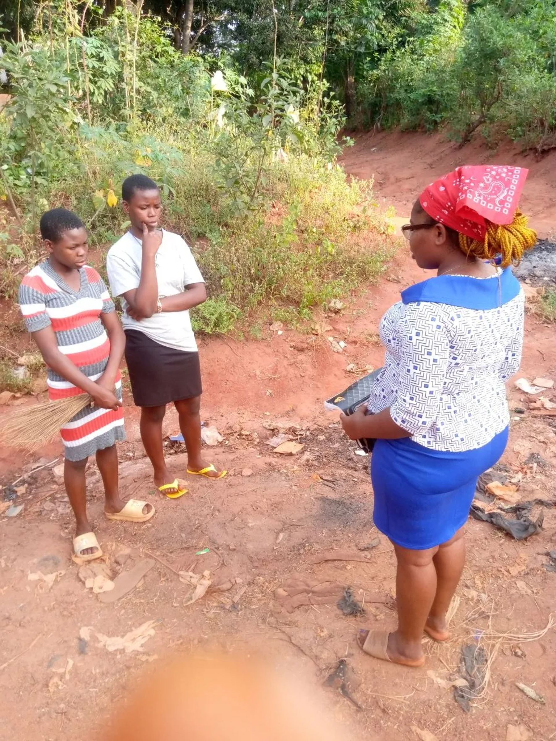 A team member talking with two young people on a village path