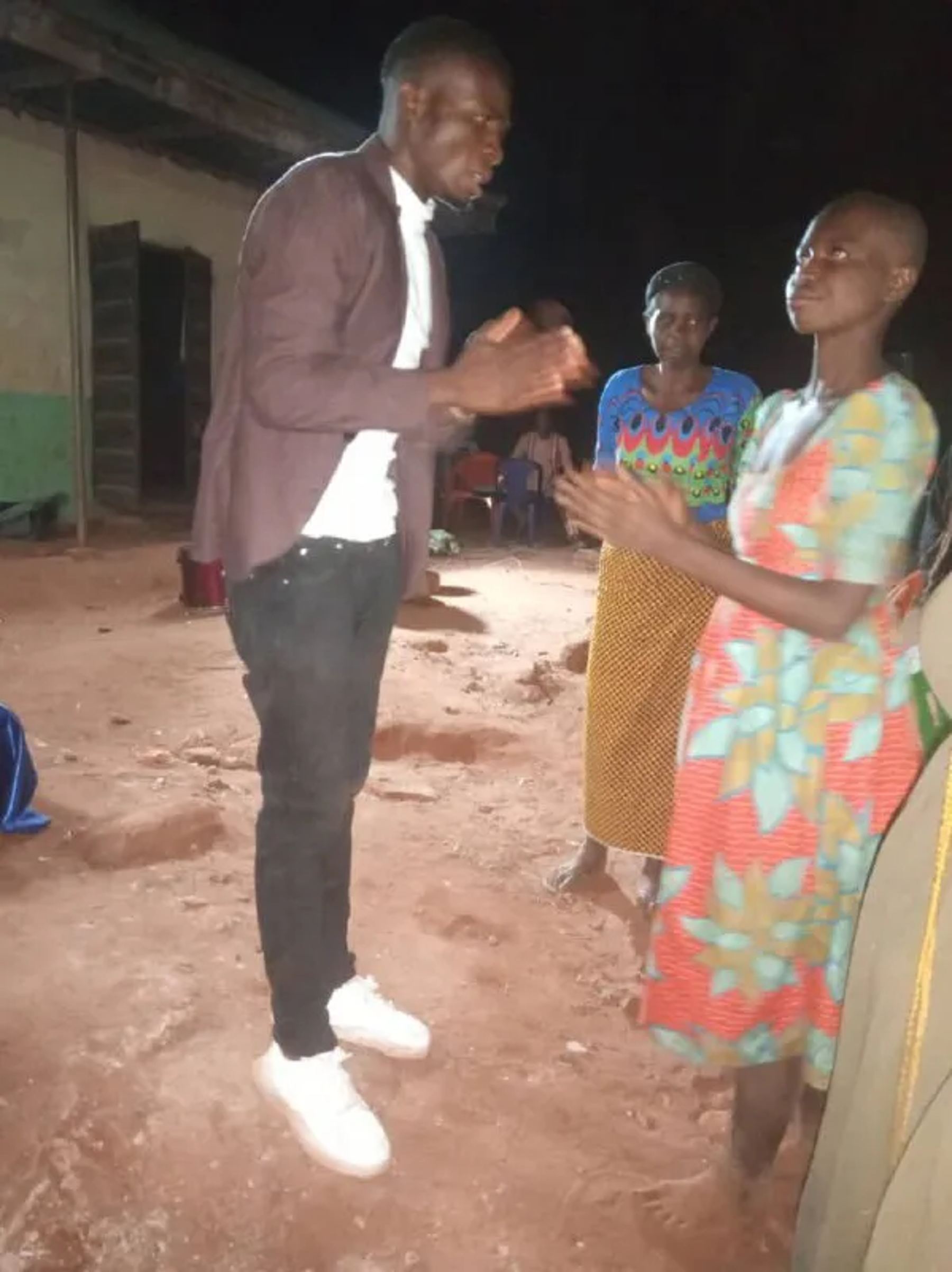 A team member praying with two women