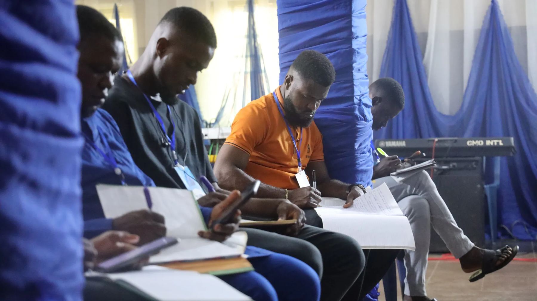 Participants seated in a row taking notes during a session