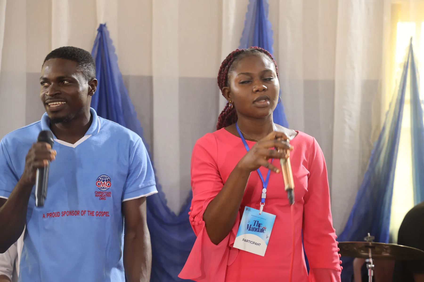 Two participants with microphones leading at the front of the hall