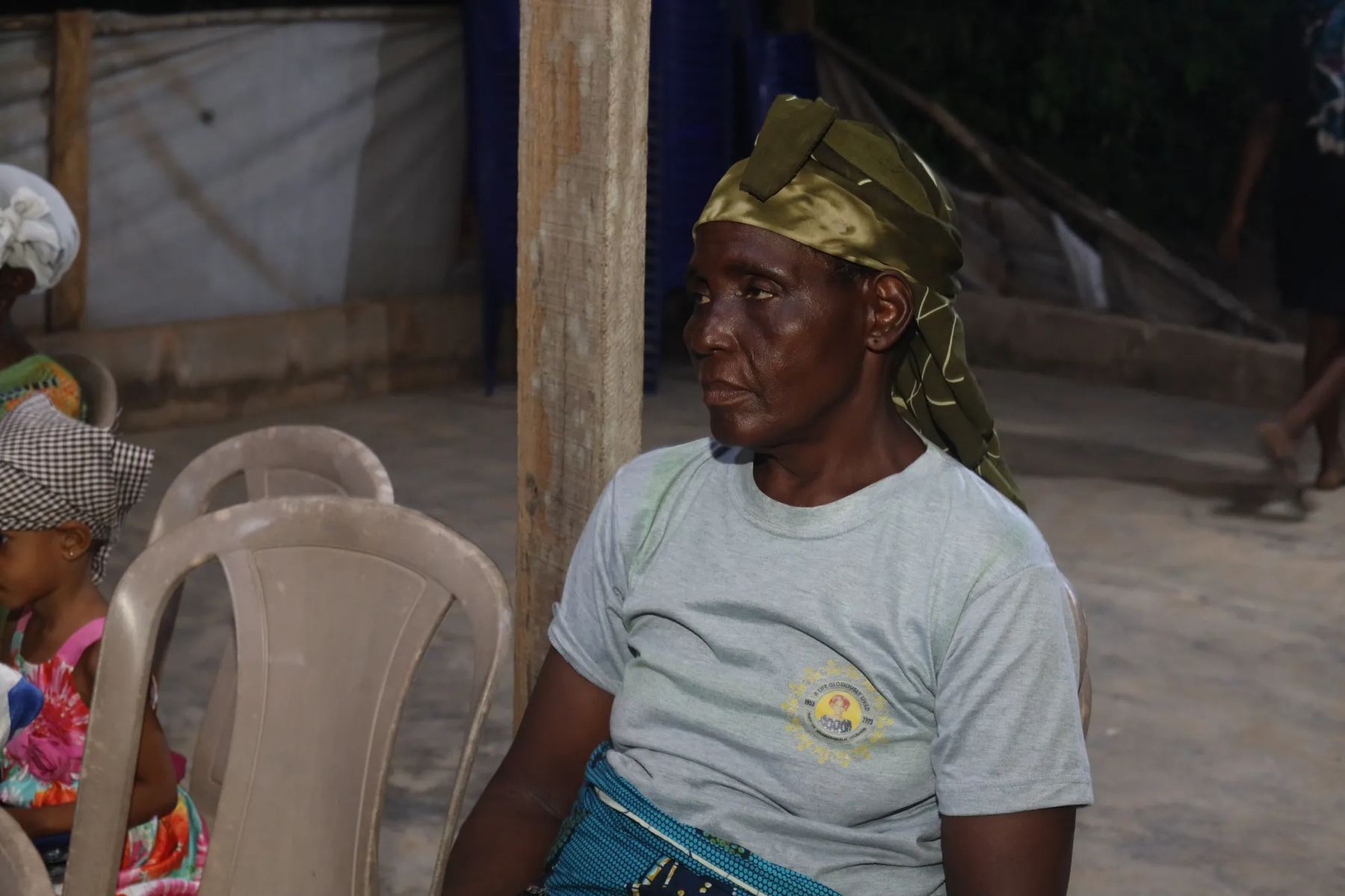 An older woman seated at the evening meeting