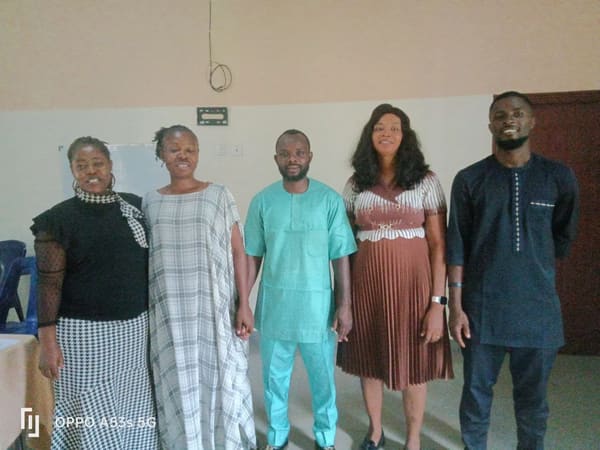 Five conference participants standing in a row in the hall
